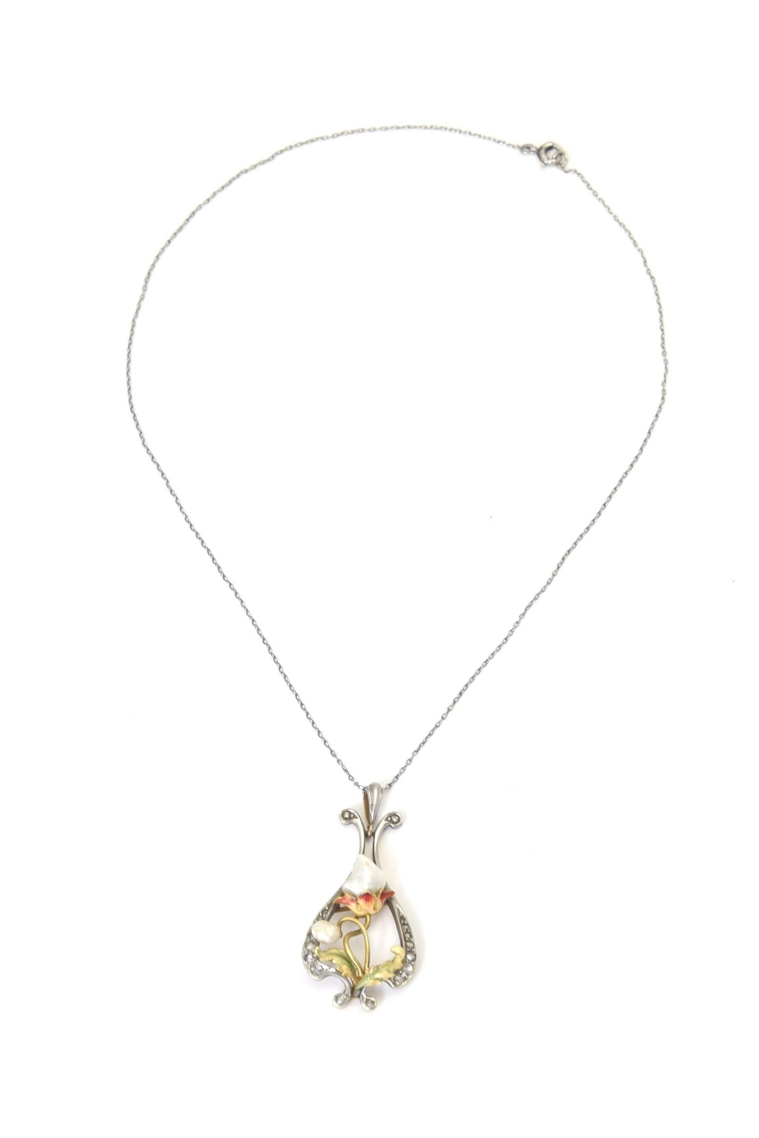 Delicate floral Art Nouveau gold pendant on a platinum chain.