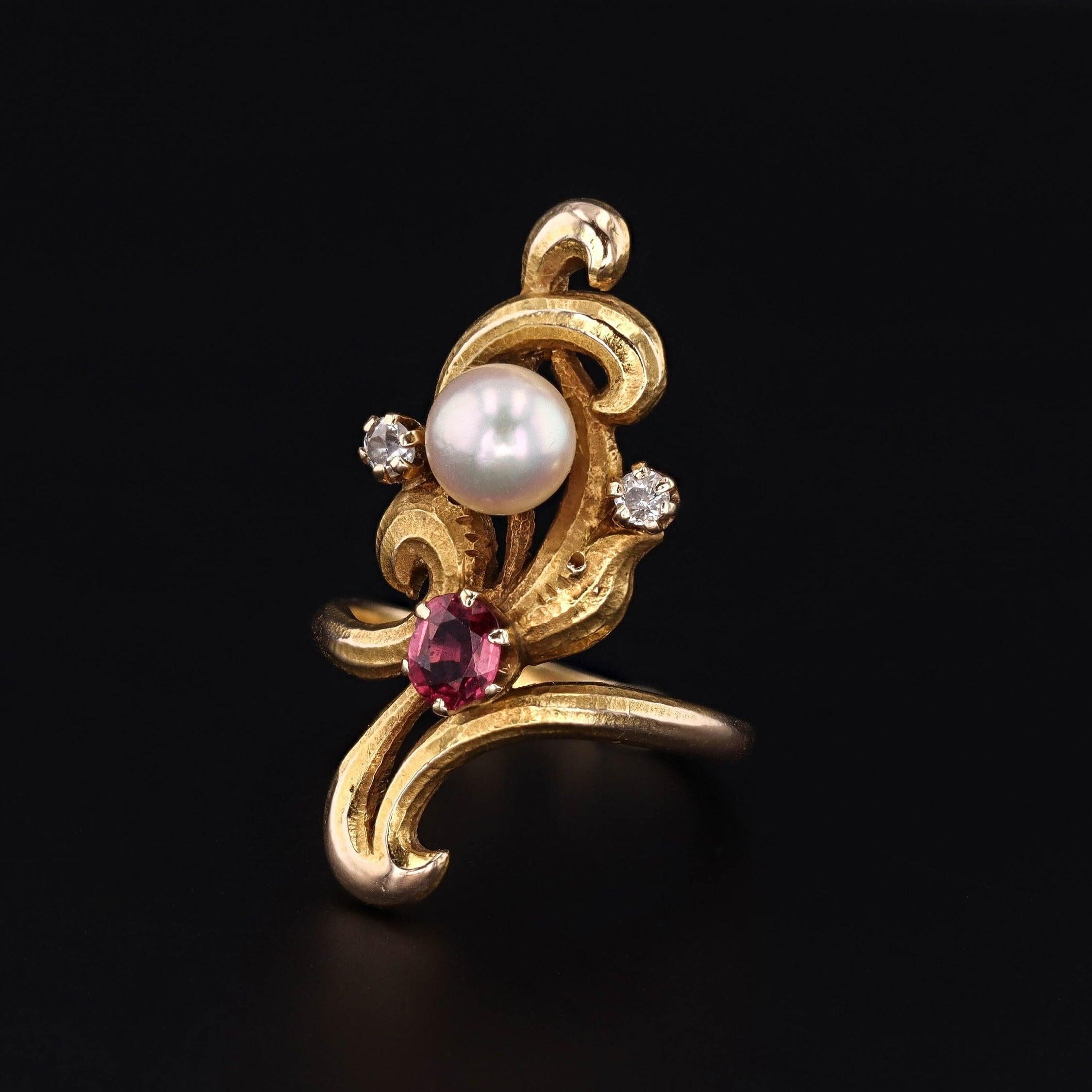 Le perle, uno dei tesori nascosti della natura, ci ricordano che spesso la bellezza più intensa si trova all'interno.

Questo antico anello in stile Art Nouveau (circa 1910) è in oro 14k con accenti di rubini, perle e diamanti.

La faccia
