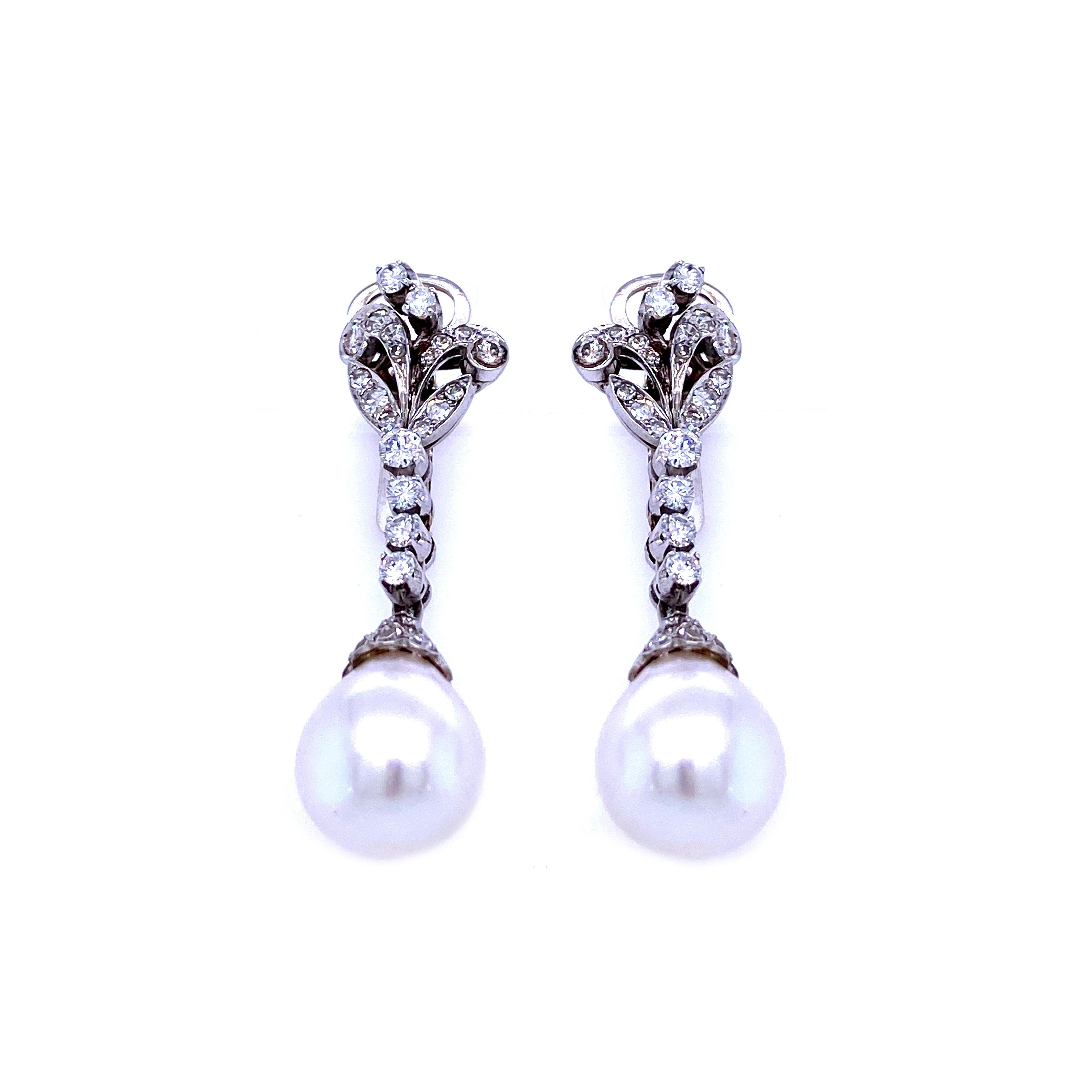 These beautiful handcrafted Original Art Nouveau diamond 18k white gold earrings feature two large Australian pearls of perfect shape, condition and color, approx. 11 mm. They are set with sparkling round brilliant cut diamonds weighing