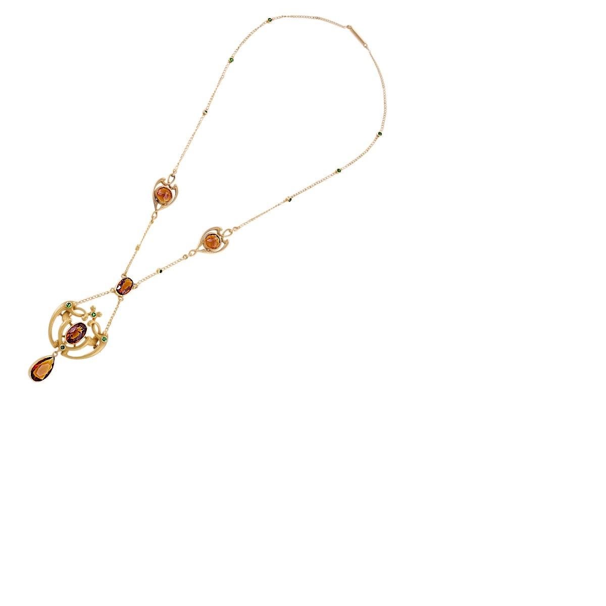 An Art Nouveau 14 karat gold pendant necklace with citrine and demantoid garnet by Bippart, Griscom & Osborn. The tiered necklace is comprised of a chandeliered pendant of intricate and classically Art Nouveau design, centering on an oval citrine