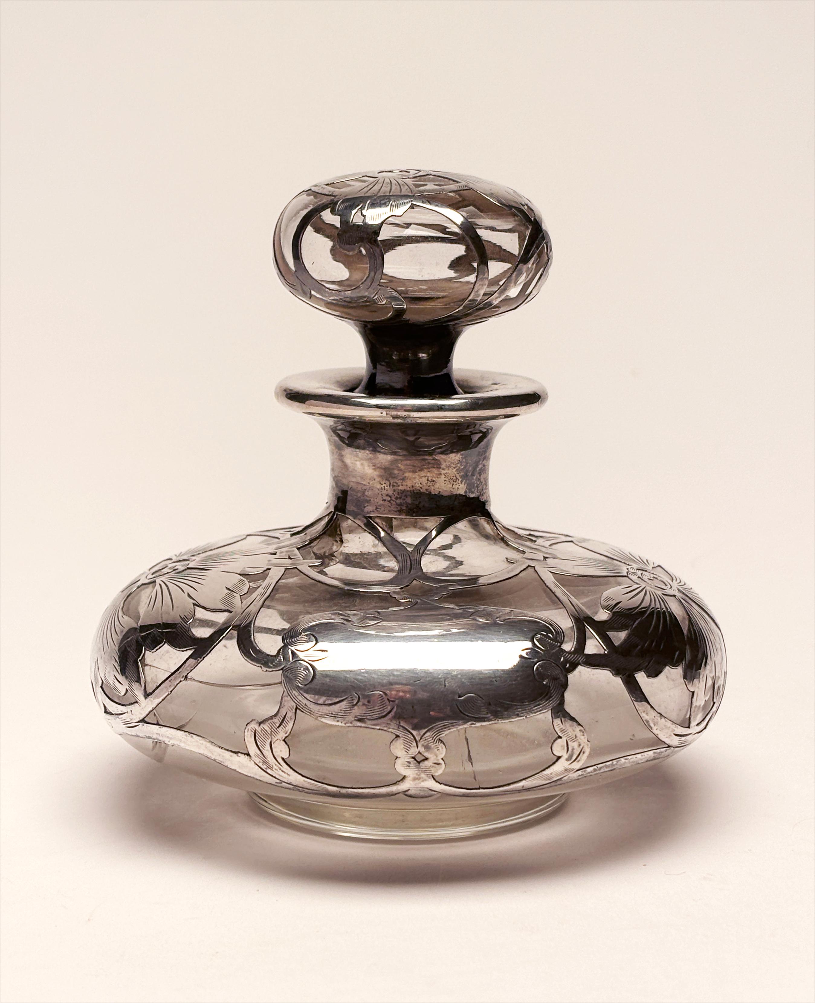 Questo bellissimo pezzo d'arte funzionale è uno splendido riflesso dell'epoca Art Nouveau da cui proviene. Utilizzata principalmente come bottiglia di profumo, questa splendida opera d'arte è stata creata applicando l'argento sterling a caldo sul