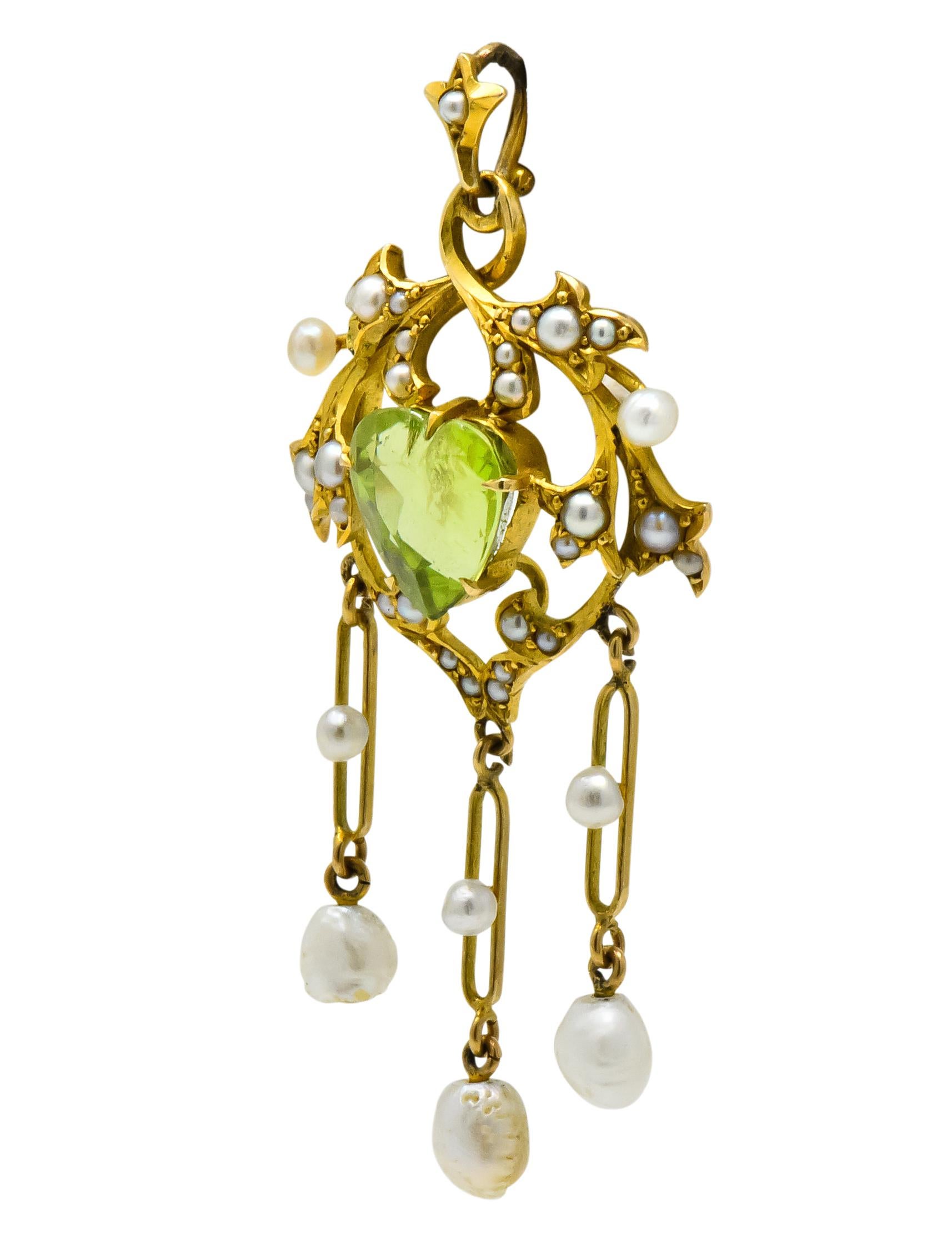 Centering a claw set, heart cut peridot measuring approximately 8.5 mm x 8.0 mm

Surrounded by stylized foliate, set throughout with seed pearls, varying in body color 

With three elongated link drops terminating in baroque pearls measuring