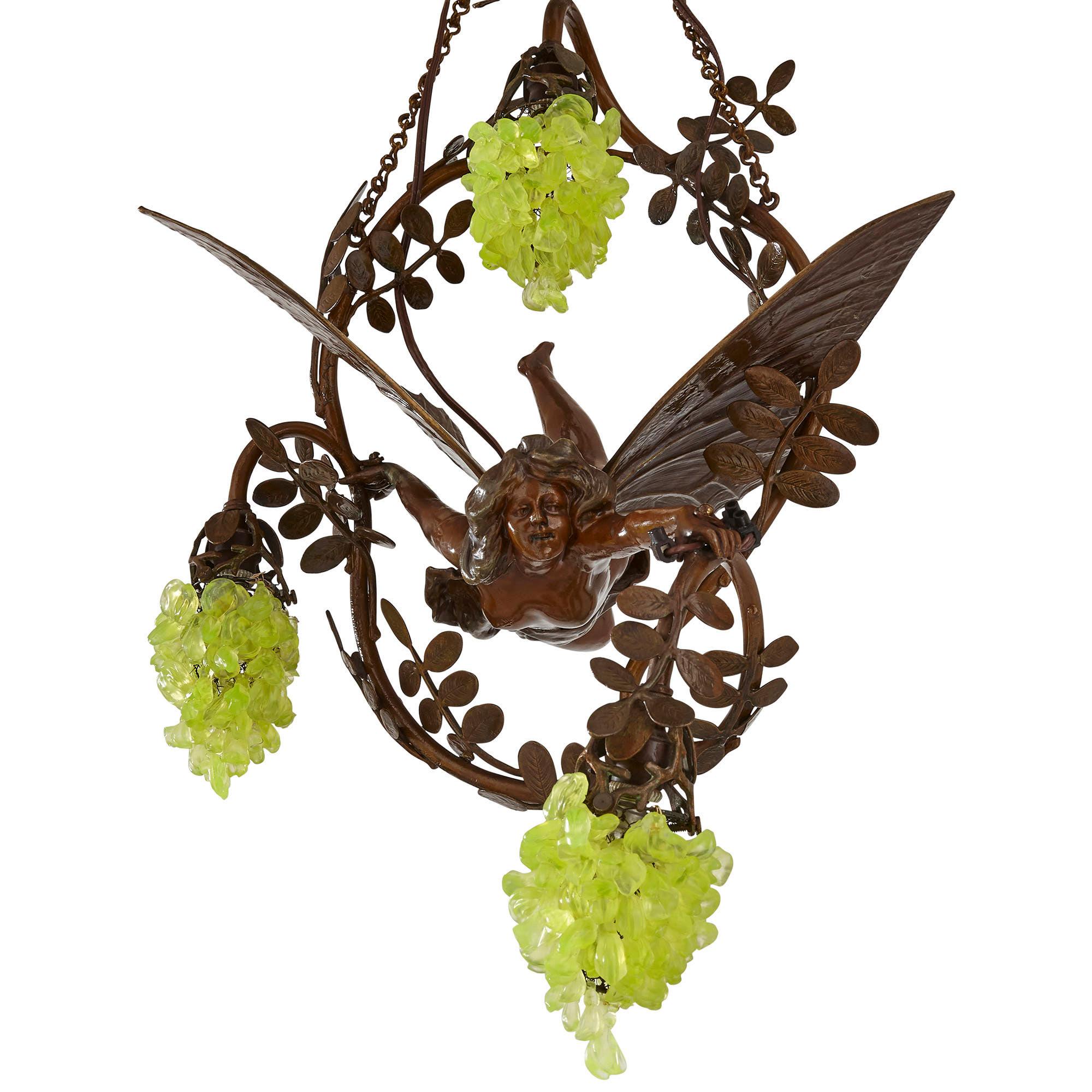 This marvellous three-light Art Nouveau patinated bronze and glass chandelier would make a charming addition to any room. The body of the chandelier is formed of a large patinated bronze loop, the loop cast to imitate a vine, with branchlets and