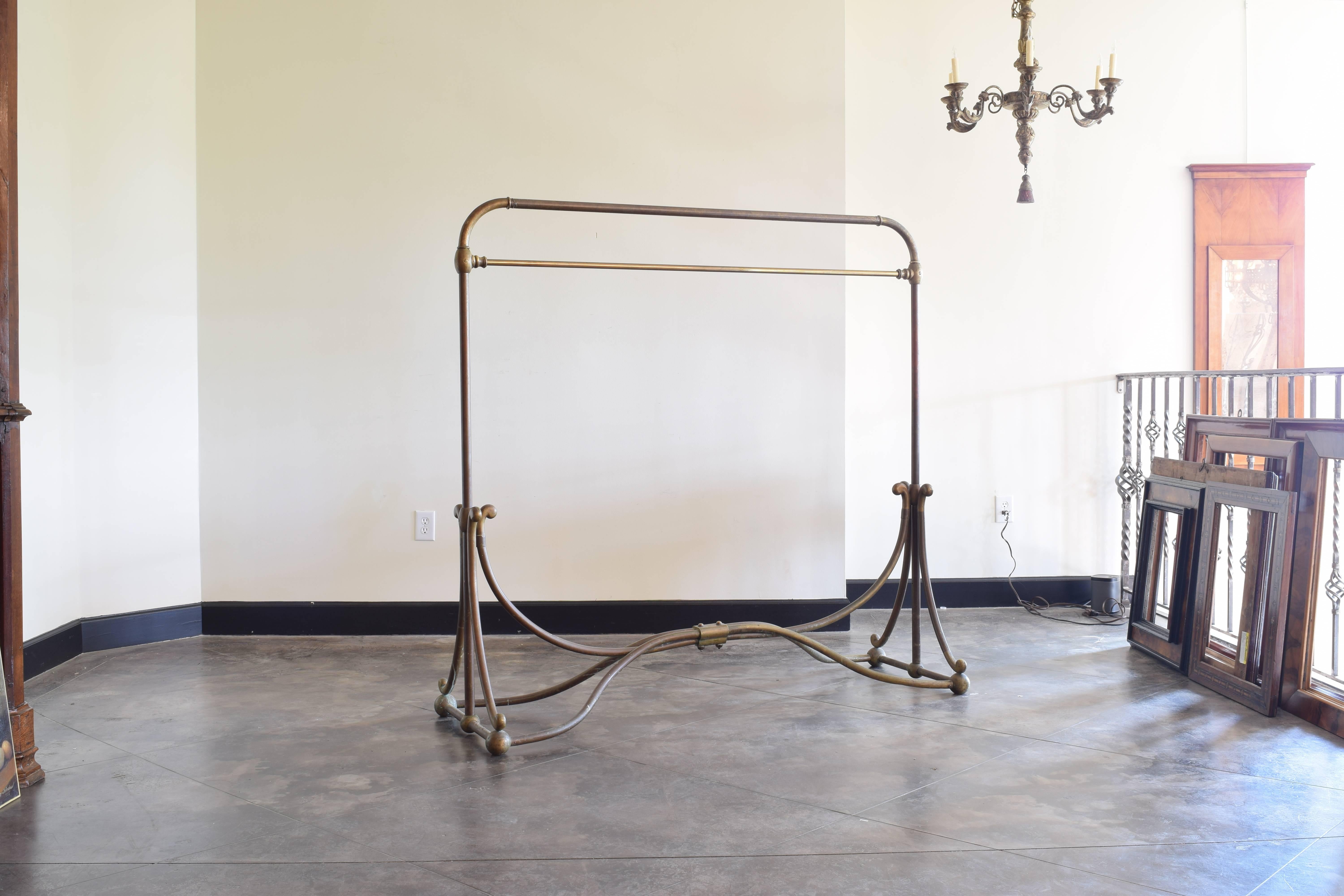 Retaining aged patina, the rack is sturdy and complete and features an Art Nouveau inspired base, the stretcher rising to join at the middle, the vertical supports receiving the stretchers with overturned details.