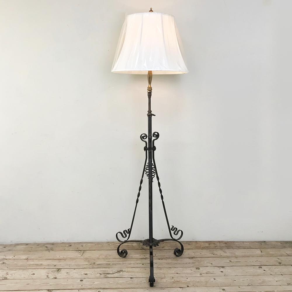 ¡La lámpara de pie de hierro forjado de época Art Nouveau es una obra maestra del arte del herrero! Ingeniosamente diseñado con una base de trípode de audaces volutas, presenta contrafuertes artísticamente esculpidos que vuelven a unirse en el