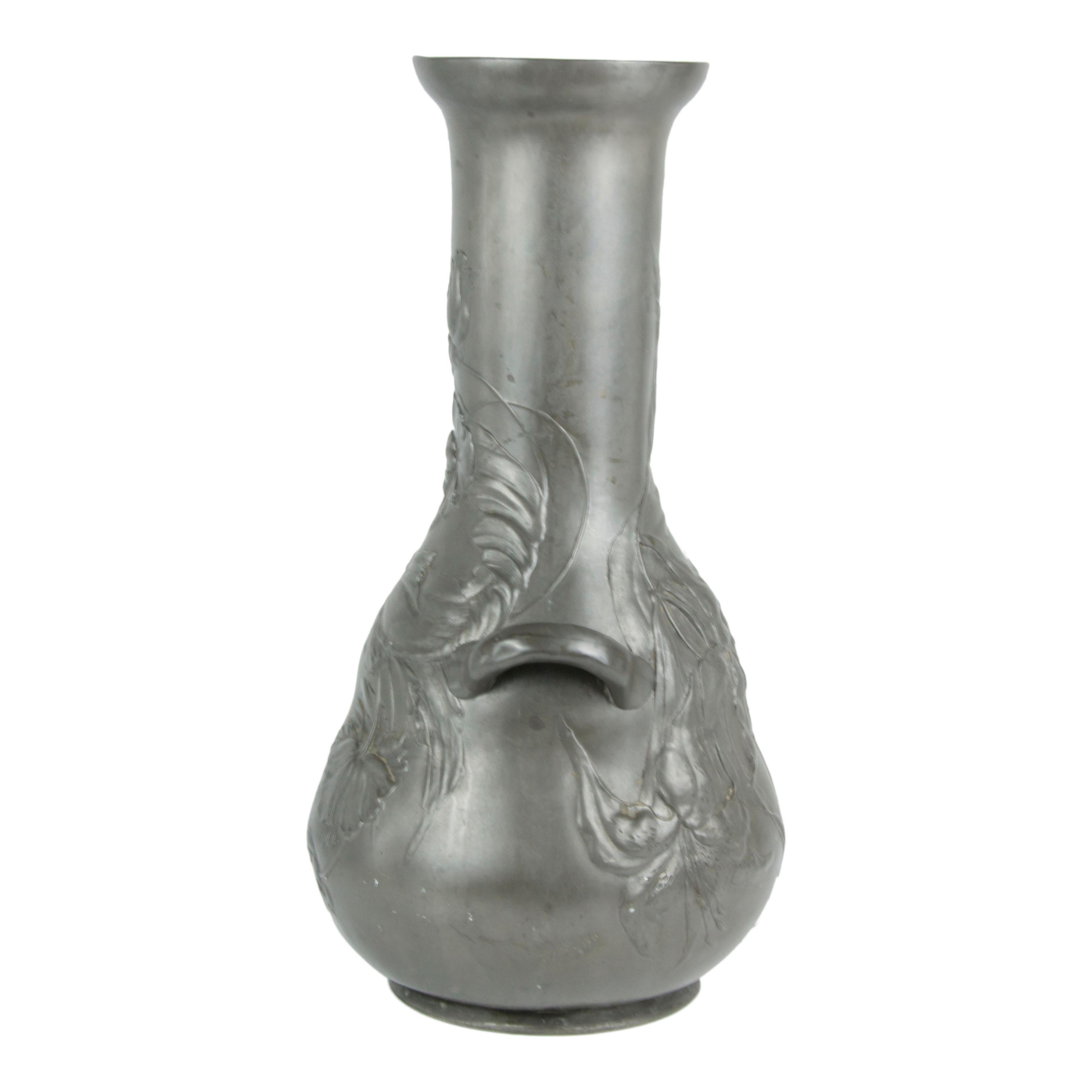 Monumental pewter vase; German; ca 1885-1910; molded pewter, having a gourd-shaped body, long neck, and inward-flared lip with low relief irises and peonies enveloping the base and neck; applied molded lug handles; marked 