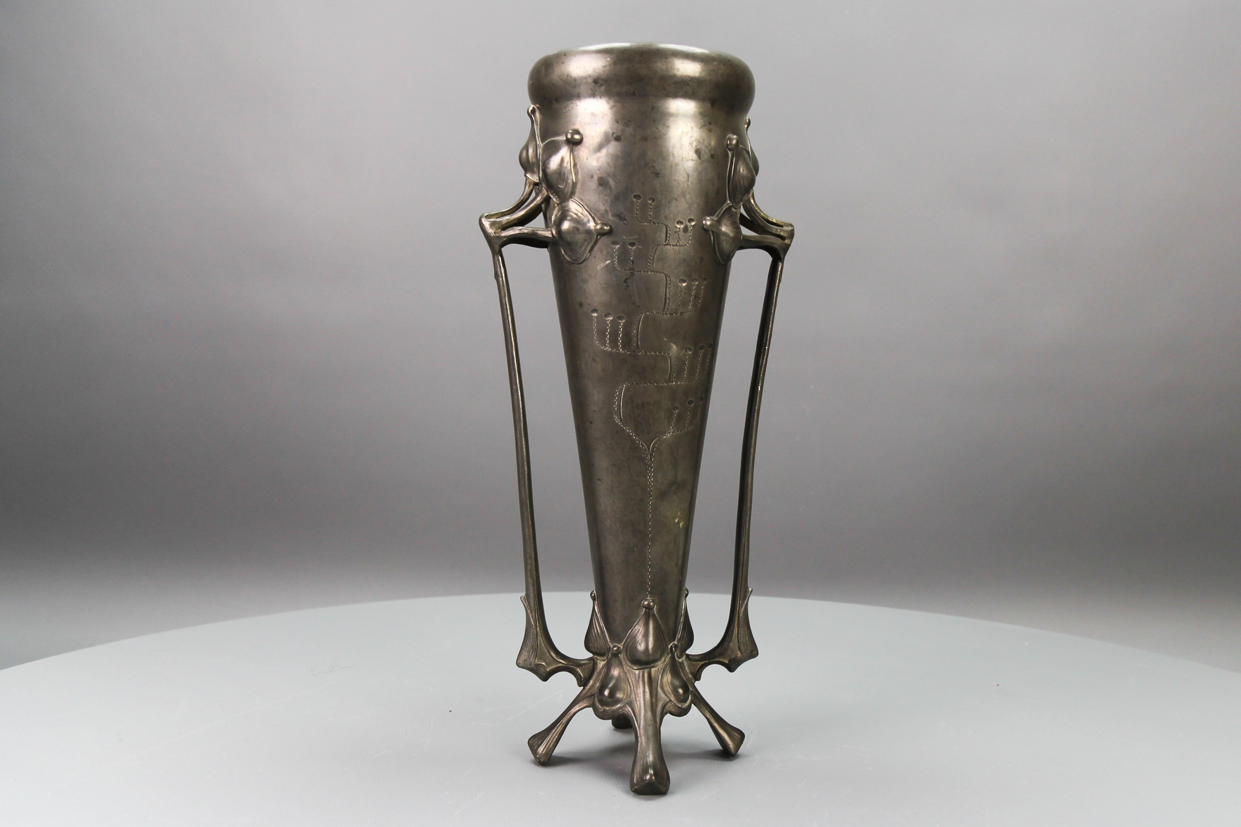 Art Nouveau Pewter Vase, Early 20th Century, France.
This beautiful Art Nouveau period conical vase on 4 leaf-like feet features tall, flowering plant-shaped elongated handles and engravings of stylized tendrils.
Dimensions: height: 38 cm / 14.96