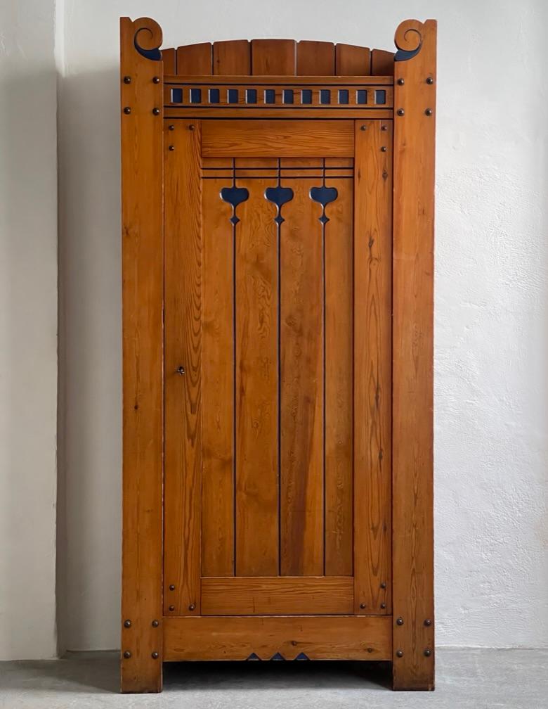This unique and remarkable Danish Art Nouveau pine cabinet, a creation of architect Hans Karl Kristensen during the years 1910-1920 in Ry, Denmark, stands as a captivating exemplar of the Jungen style, a Danish interpretation of the broader European