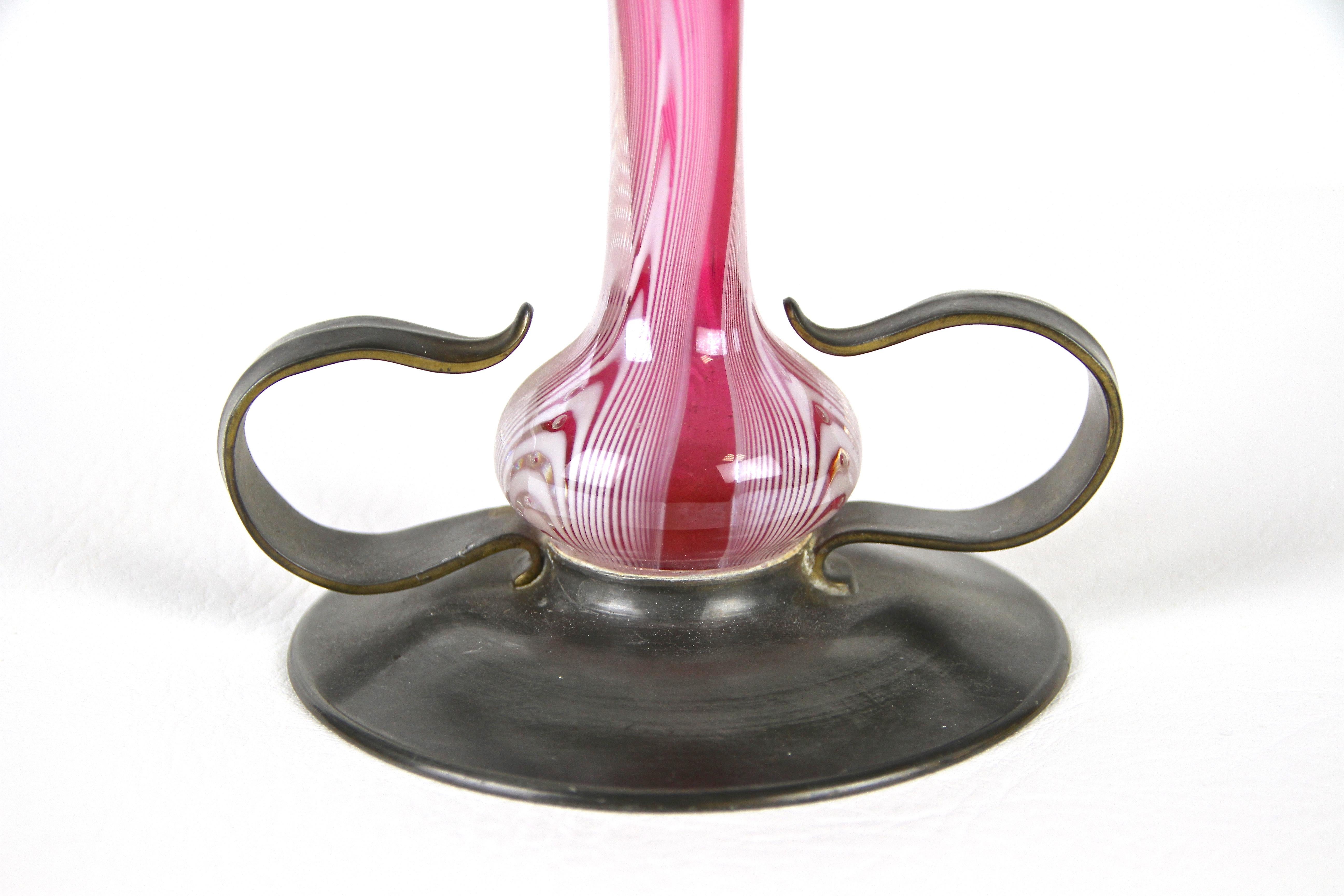 Beautiful Art Nouveau glass vase on brass stand out of Austria from the period around 1900. Mouth blown of pink glass and additionally adorned by delightful melted white glass threads, this extraordinary early 20th century glass vase impresses with