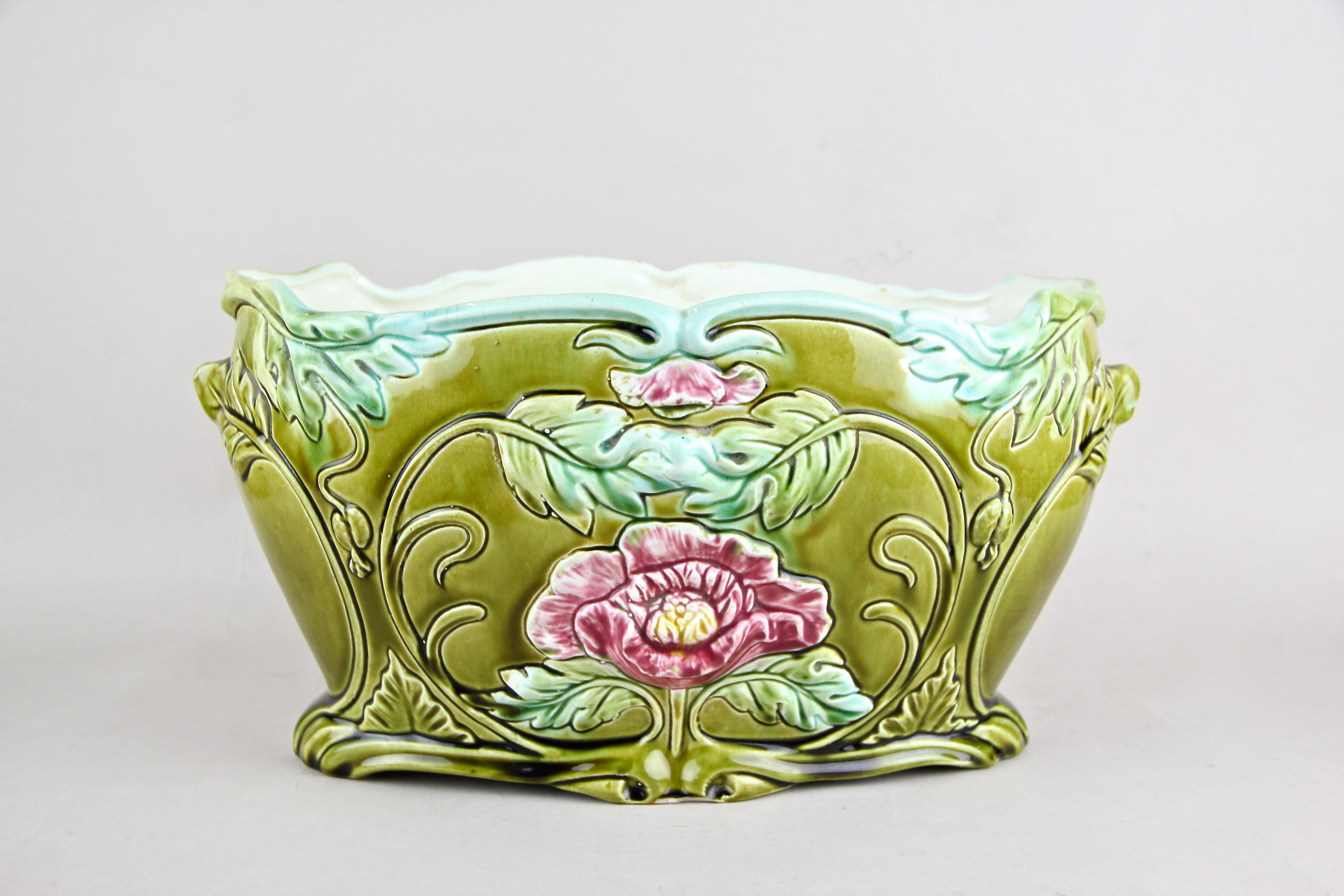 Fantastic ceramic planter or jardinière from France, circa 1910. This floral designed planter or jardinière just looks fantastic in combination with the wonderful worked blossoms on the front and the back. A great coloring and the unique shape makes