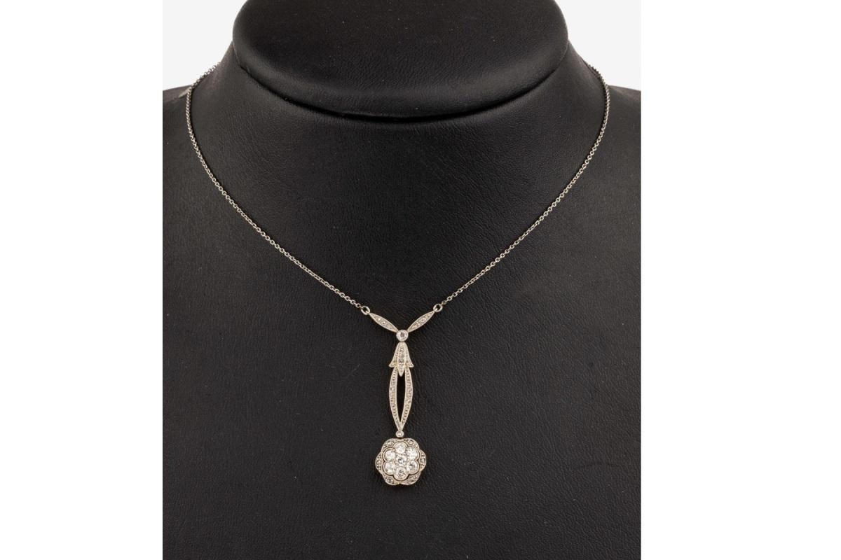 Elegante collana in stile Art Nouveau, realizzata in platino con elementi in oro giallo da 14 carati. Questa collana unica è decorata con numerosi diamanti taglio vecchio, per un peso totale di circa 0,60 ct. Diamanti di colore H-J e purezza