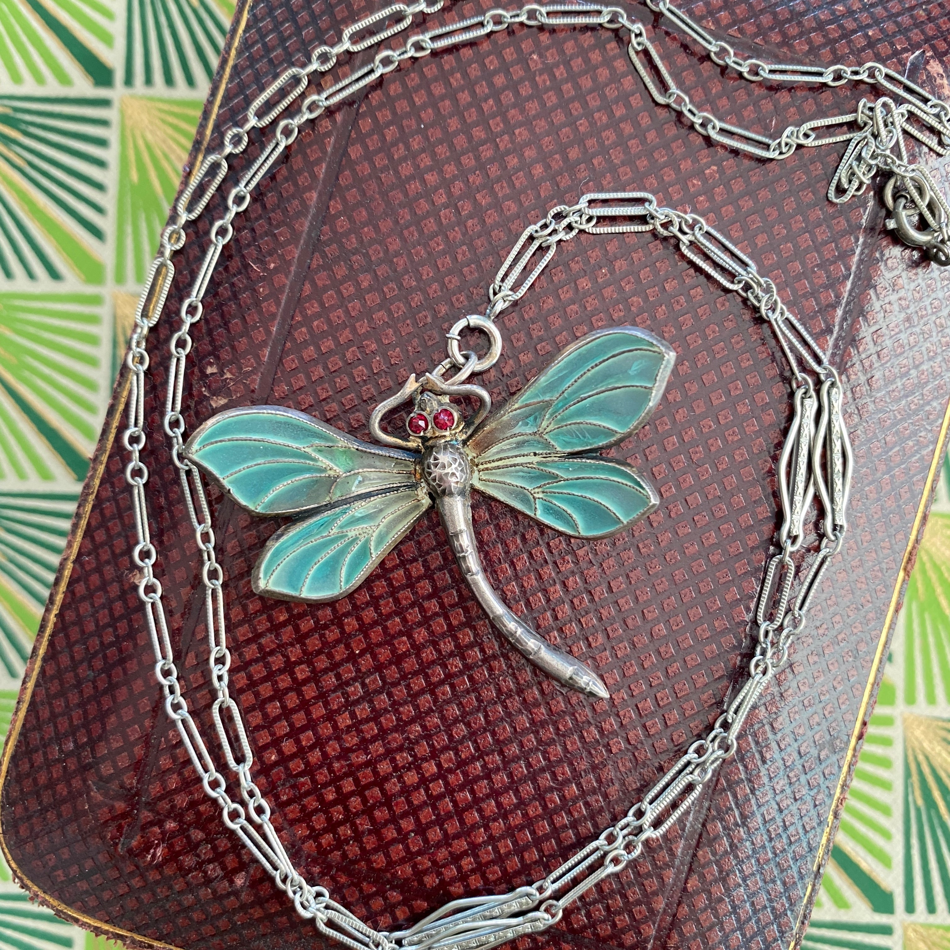 Details:
Plique-a-Jour Art Nouveau dragonfly pendant necklace in sterling silver in beautiful shades of blue and green with little bright red eyes—possibly ruby or maybe paste, not tested. Plique-a-jour is an enamel process from the 15th century