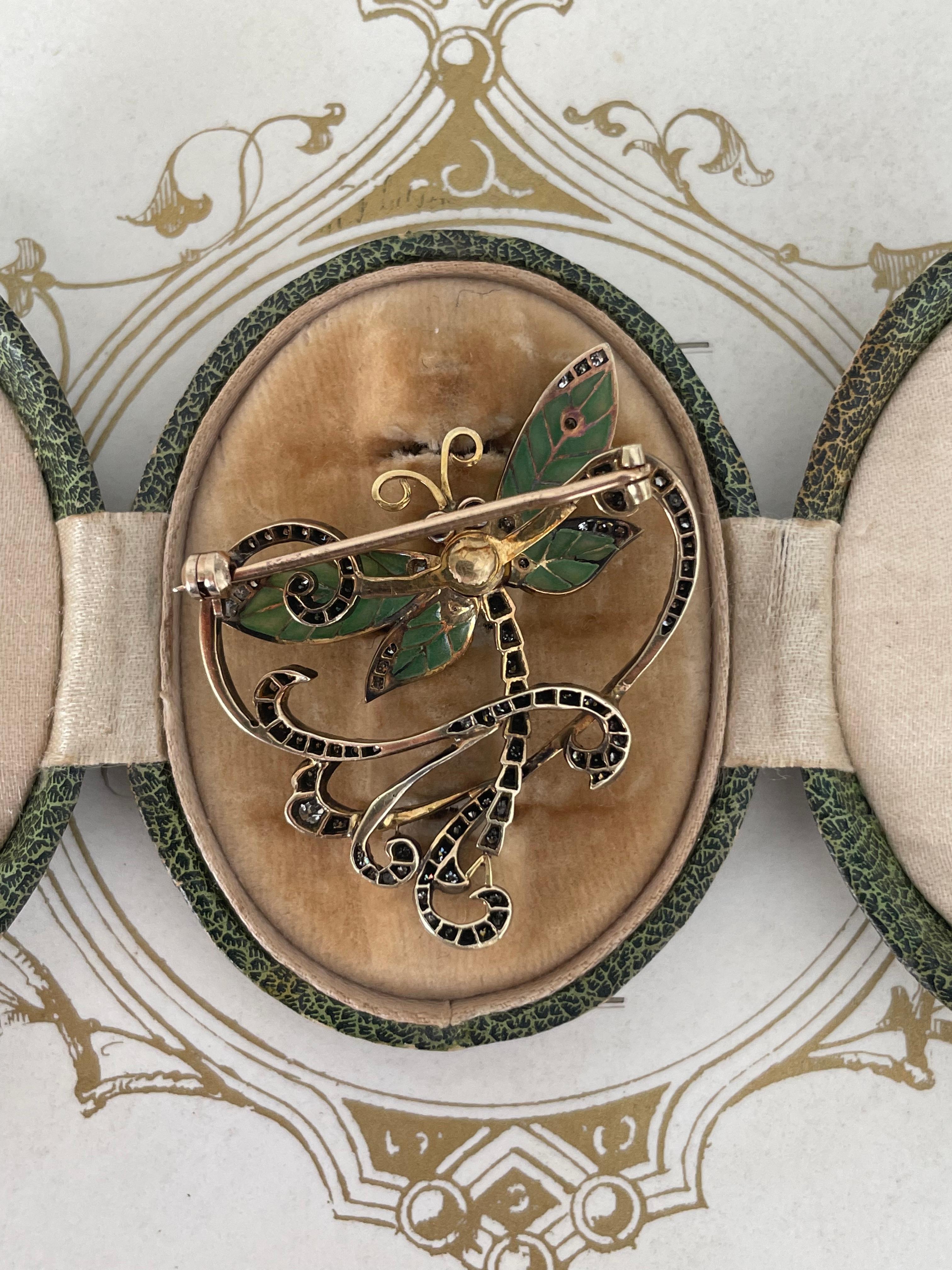 A beautiful symbol of grace and change, perfectly embodied in this enchanting Art Nouveau dragonfly brooch. A flutter with fern green plique-a-jour wings, a diamond lined abdomen and two cabochon ruby eyes, finished with a sparkling diamond whip