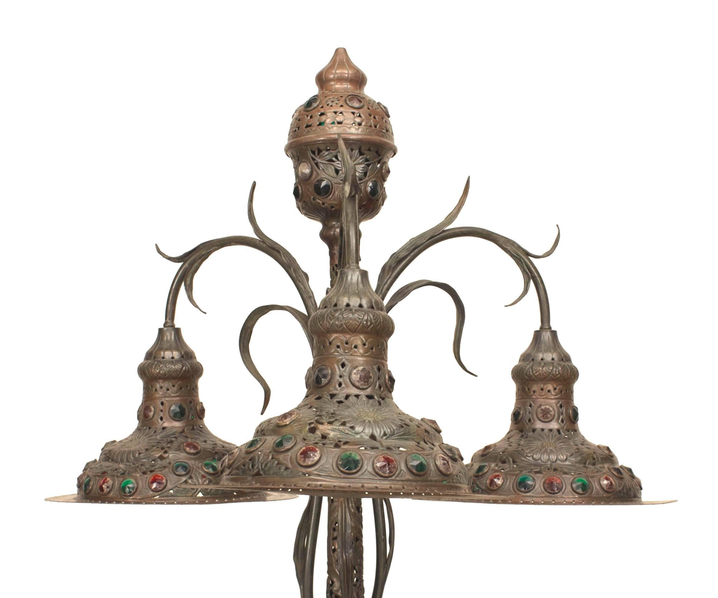 Art Nouveau (possibly Hungarian) floor lamp with a dark green patina metal and a floral and vine filigree design. Inset glass jewels and supporting 3 round hanging shades.
