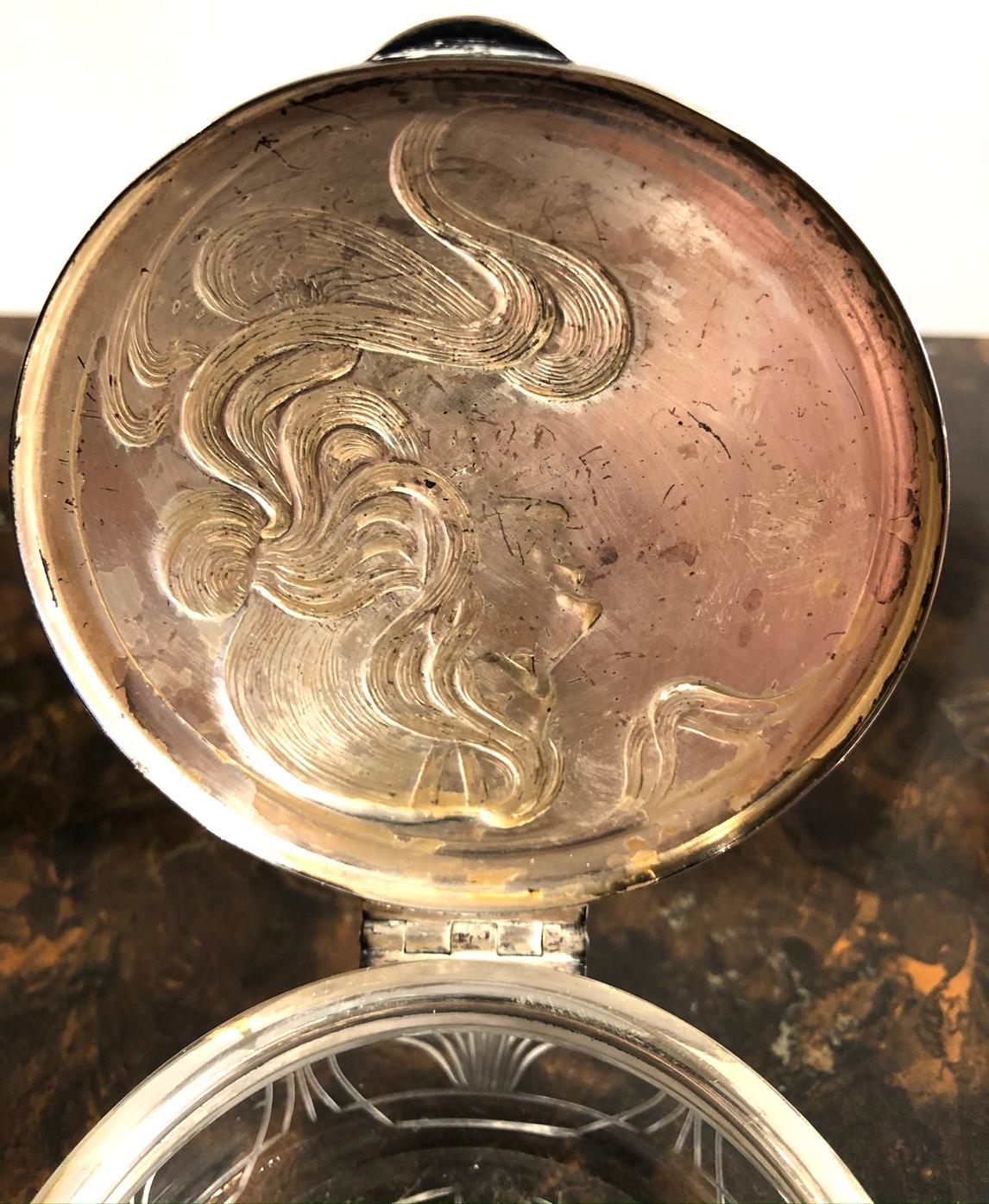 Powder jar. Glass and metal. No markings. Features a decorative profile of a woman. The jar is pressed glass. Nicely made.