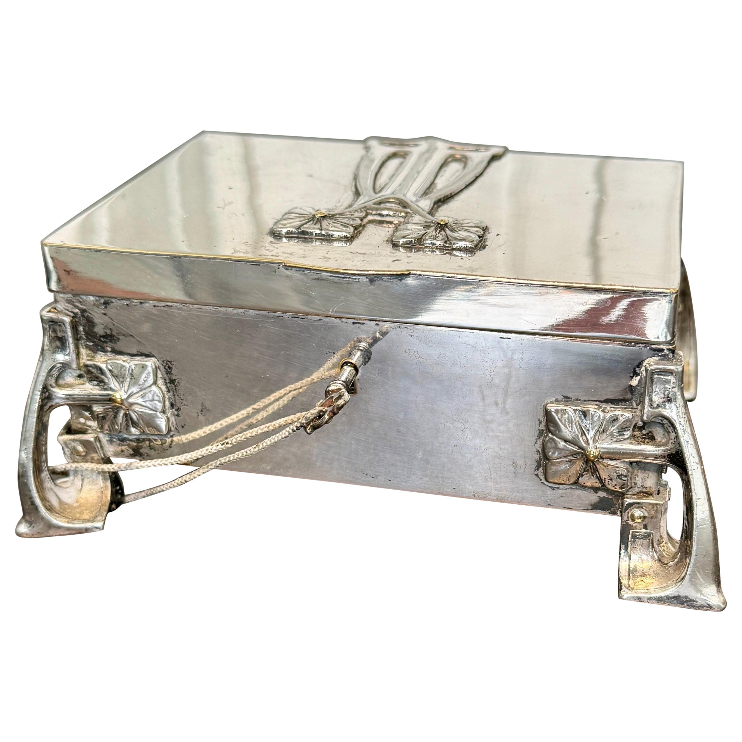 Esta caja rectangular francesa de plata está profusamente decorada en los estilos típicos de este periodo Art Nouveau. La caja tiene el interior de terciopelo rojo vintage y los herrajes originales con cerradura y llave que funcionan. El estado de