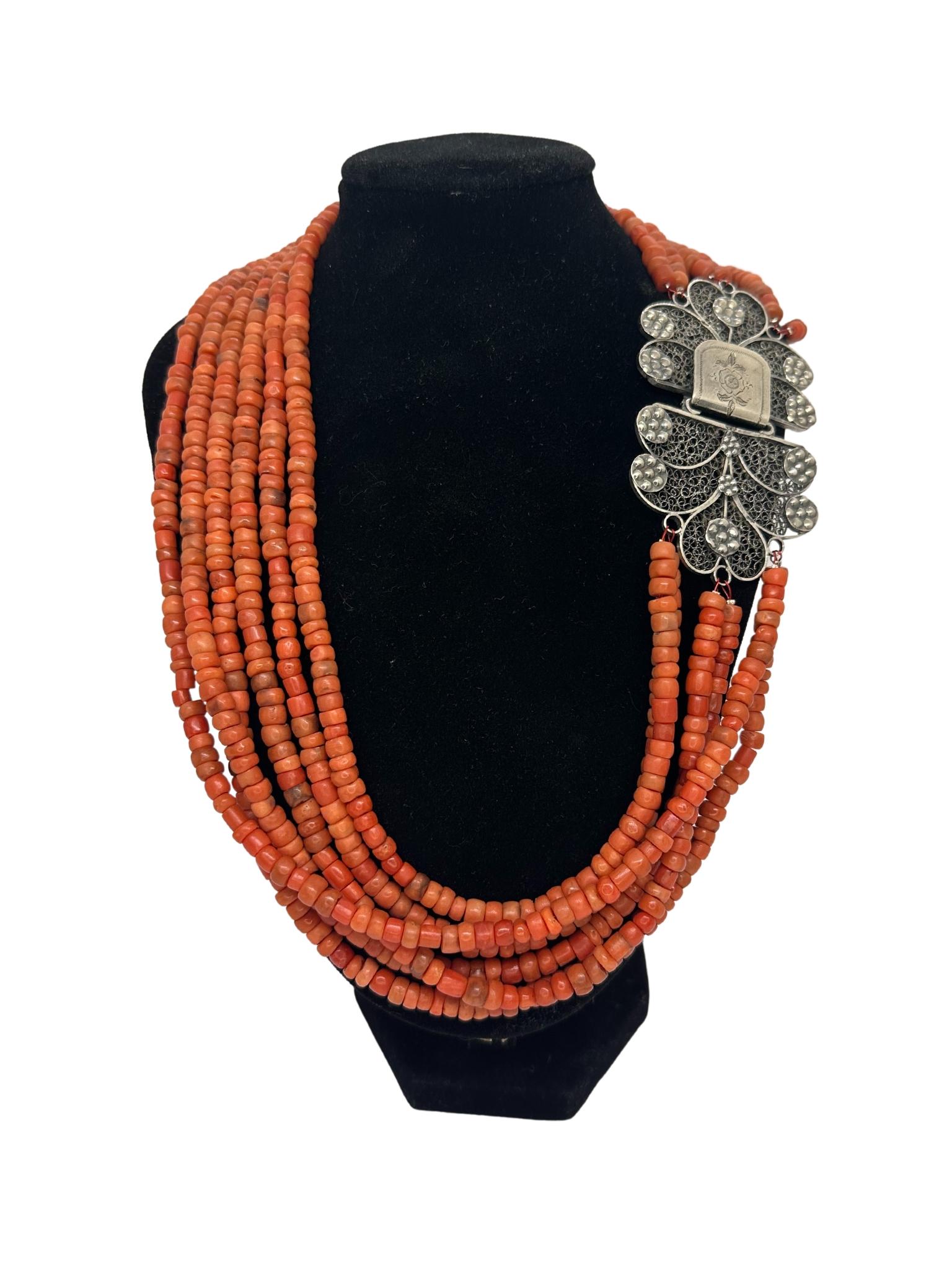 Exclusive and very refined Italian red coral necklace with 835 silver clasp closure decorated with filigree. The necklace is made up of small natural undyed red coral beads that are arranged in six strands. The closure is a “hook”, hidden in the