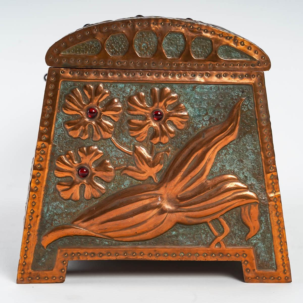 Boîte Art Nouveau en cuivre repoussé, vers 1900.

Boîte de style Art Nouveau, 1900, cuivre repoussé sur un intérieur en bois, cabochons en verre rouge, avec clé.

Dimensions : h : 17cm, l : 30.5cm, d : 18cm