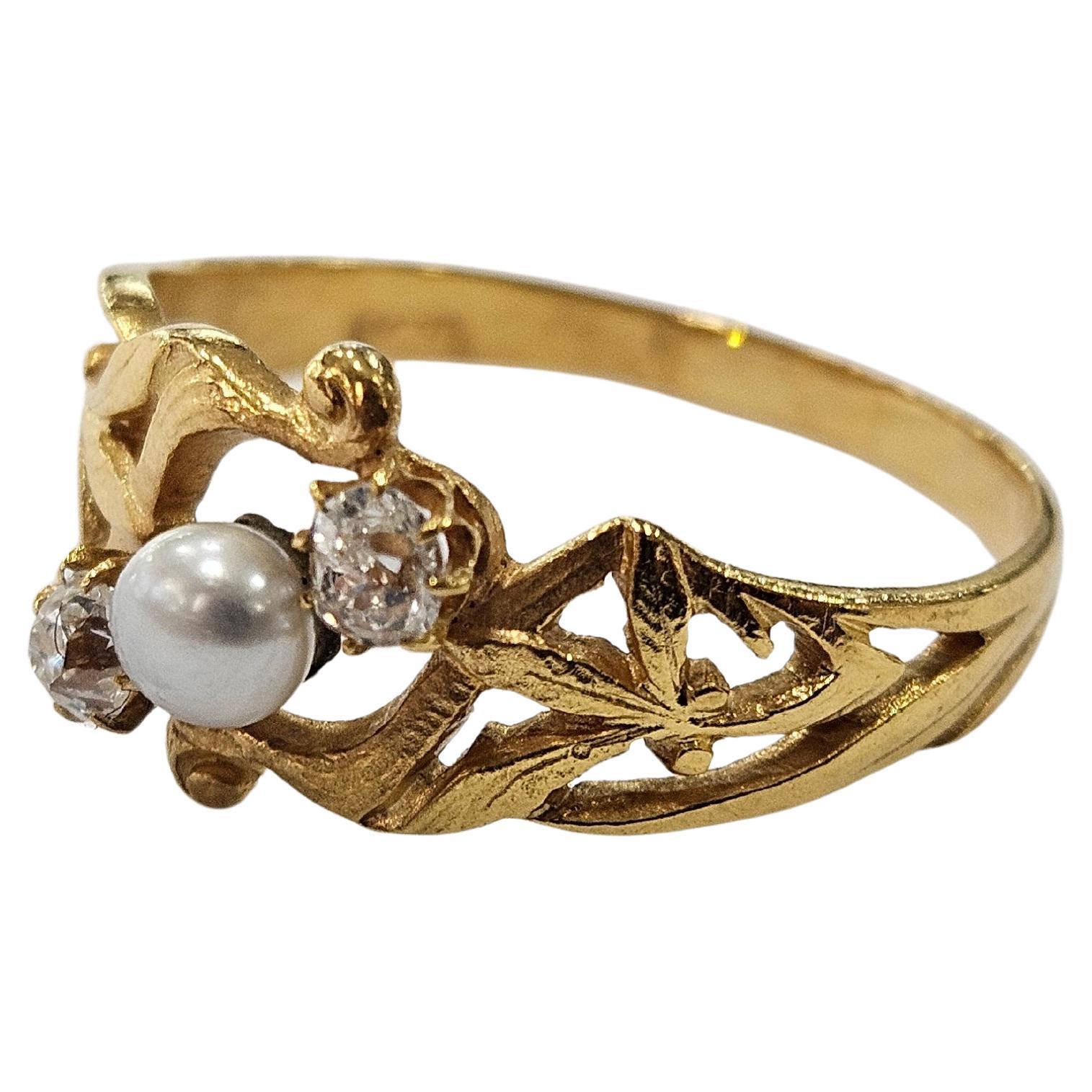 Originale e spettacolare anello Art Nouveau degli anni '20, in oro giallo 18 carati, con motivo a foglie, con una perla di coltura centrale di 3,90 mm di diametro e due diamanti antichi tagliati a mina di 0,18 carati (circa 3,40 x 3,10 x 2,50 mm). 