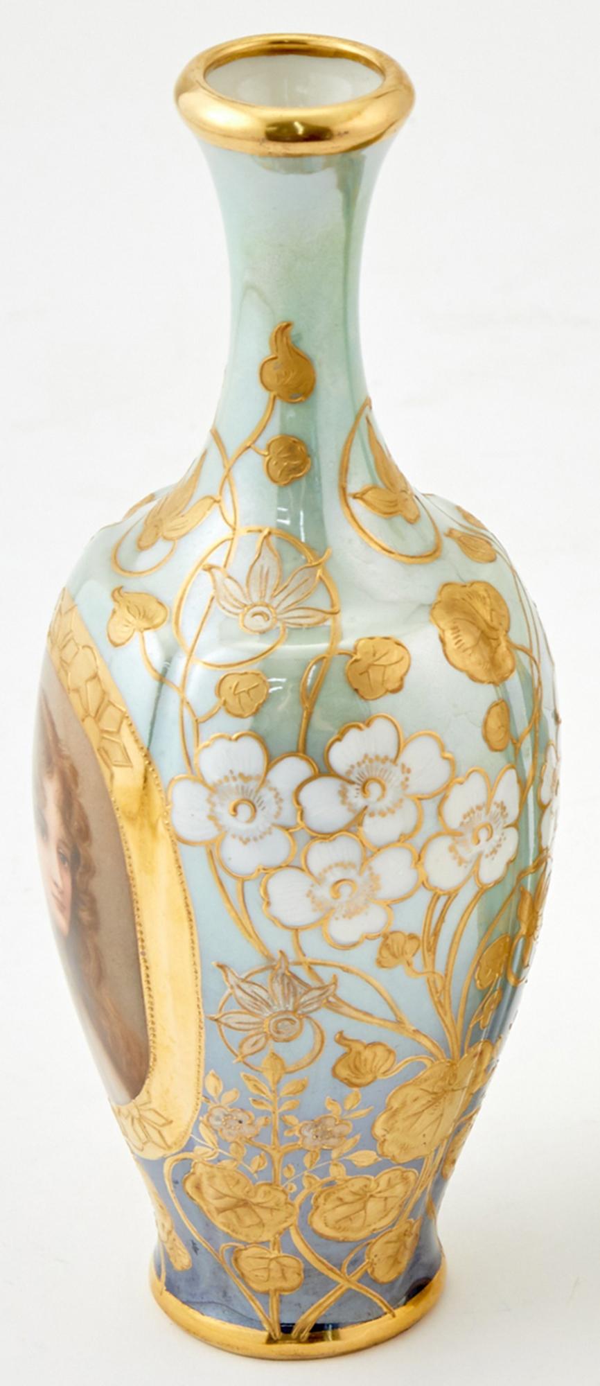 Fine royal Vienna portrait vase of a soft faced beauty with wispy hair, brown eyes and a neutral expression is encircled by a band of polychrome gold paint. Two tones of blue from the base and neck converge on the belly, creating a beautiful