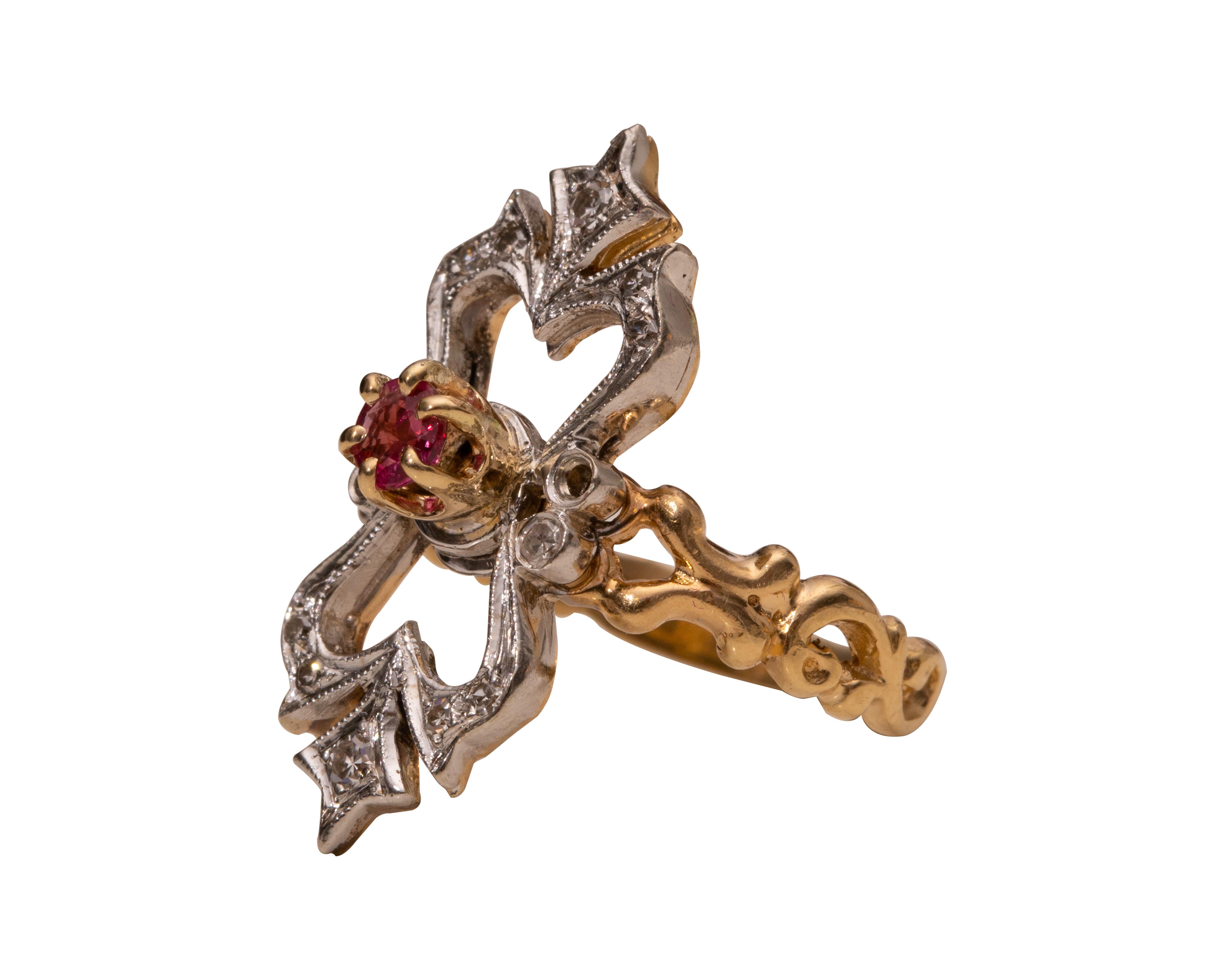 Here we have an excellent example of a 1920's era two-tone gold ring in a classic Art Nouveau style. This lovely openwork shield features a natural ruby at the center of a beautiful curvaceous white gold open design top. The top features antique