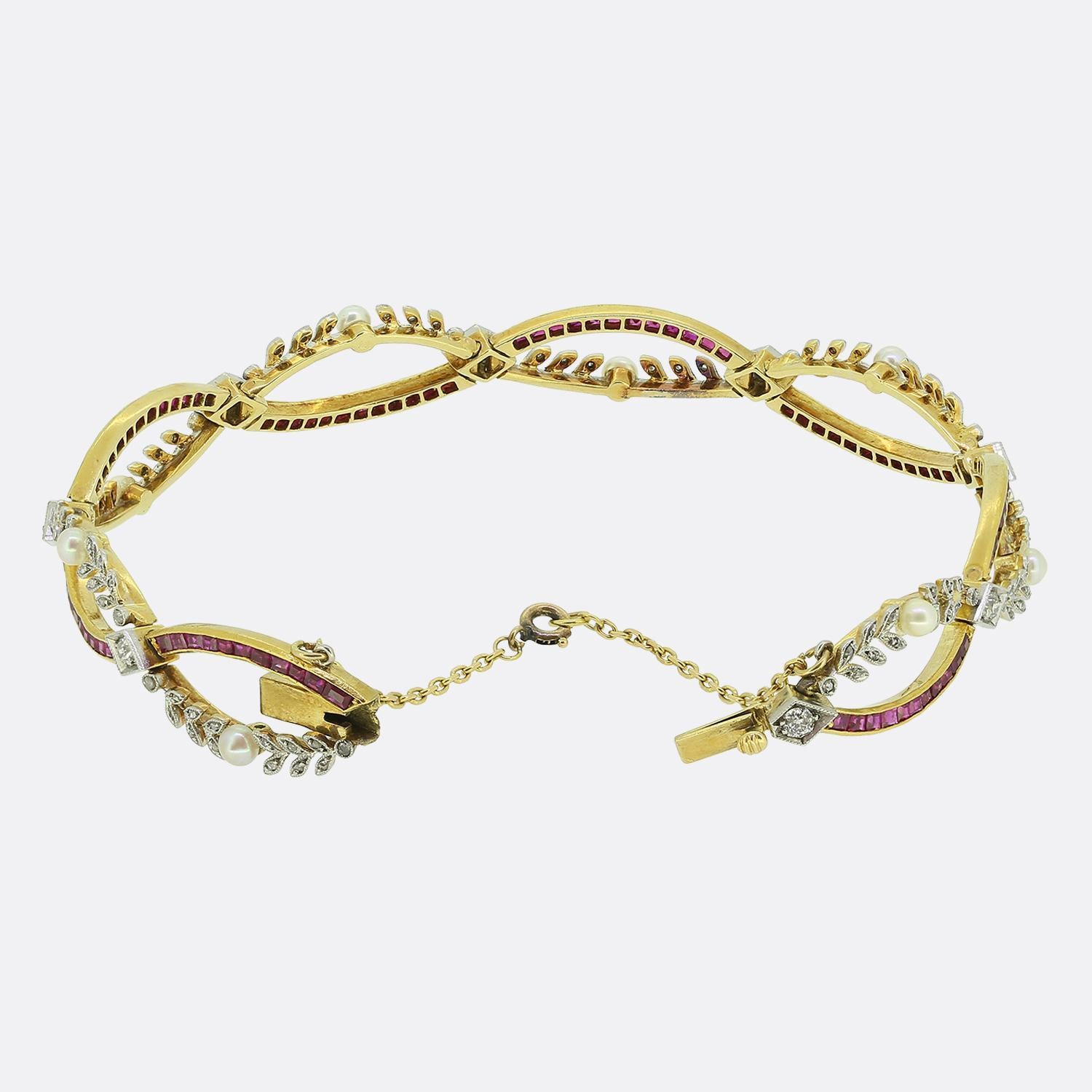 Here we have an exquisite bracelet crafted from 18ct yellow gold during the Art Nouveau movement. This piece showcases a captivating design with an oval shaped open band set with vibrant red square calibrated rubies and rose cut diamonds set within