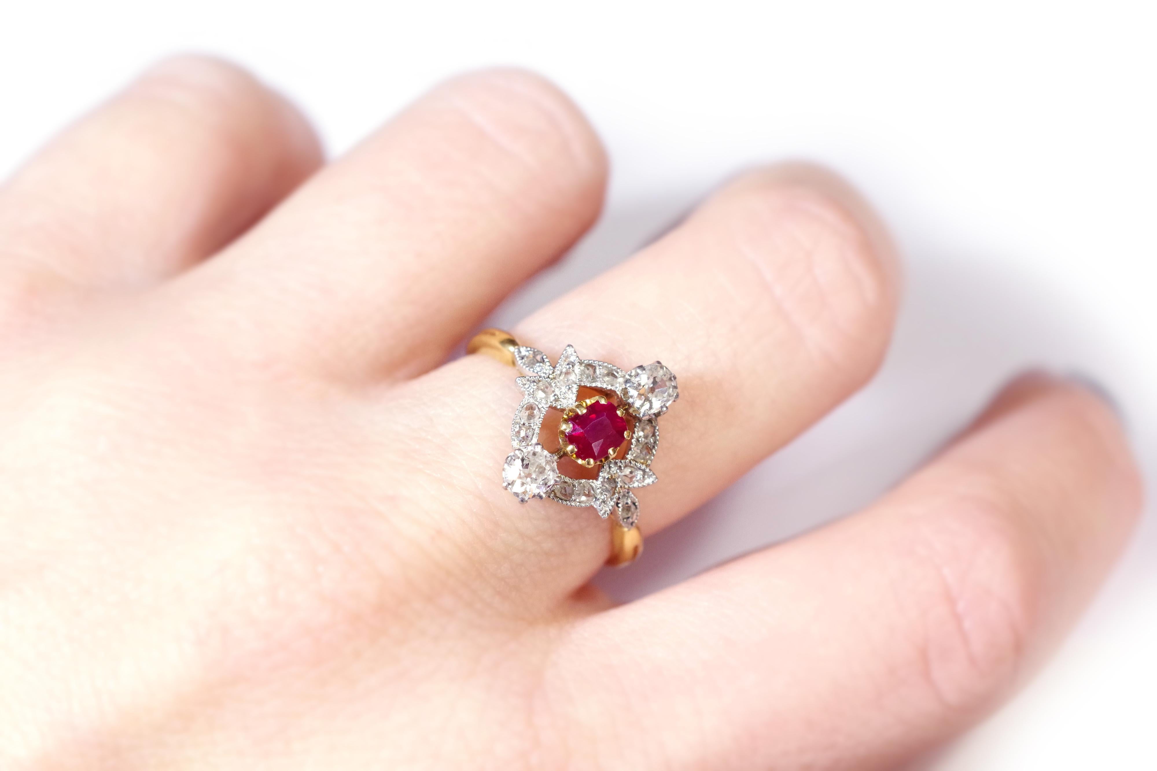 Art Nouveau ruby ring in 18 karat yellow gold and platinum. Antique ring of the Art Nouveau period decorated with a pigeon's blood ruby and diamonds. In its center there is a cushion-cut ruby. The ruby is framed by two old-cut diamonds. The whole is