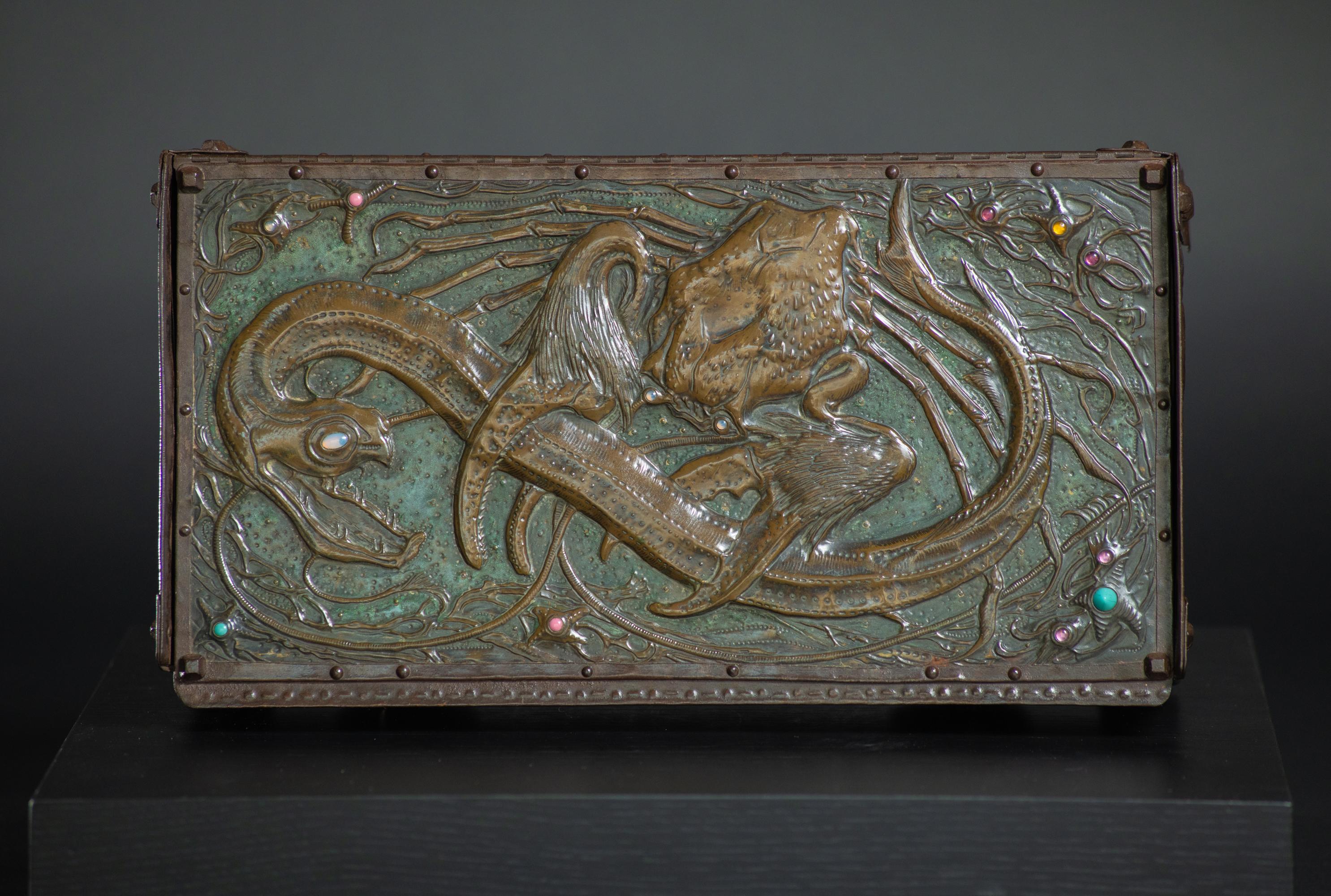 Daguet’s beautifully patinated box is a rich textural and colorful tour de force. The top of Daguet’s box is striking for its bird’s-eye-view of a crab clutching a viper eel. Using repousse and chasing techniques, Daguet creates dimension and a
