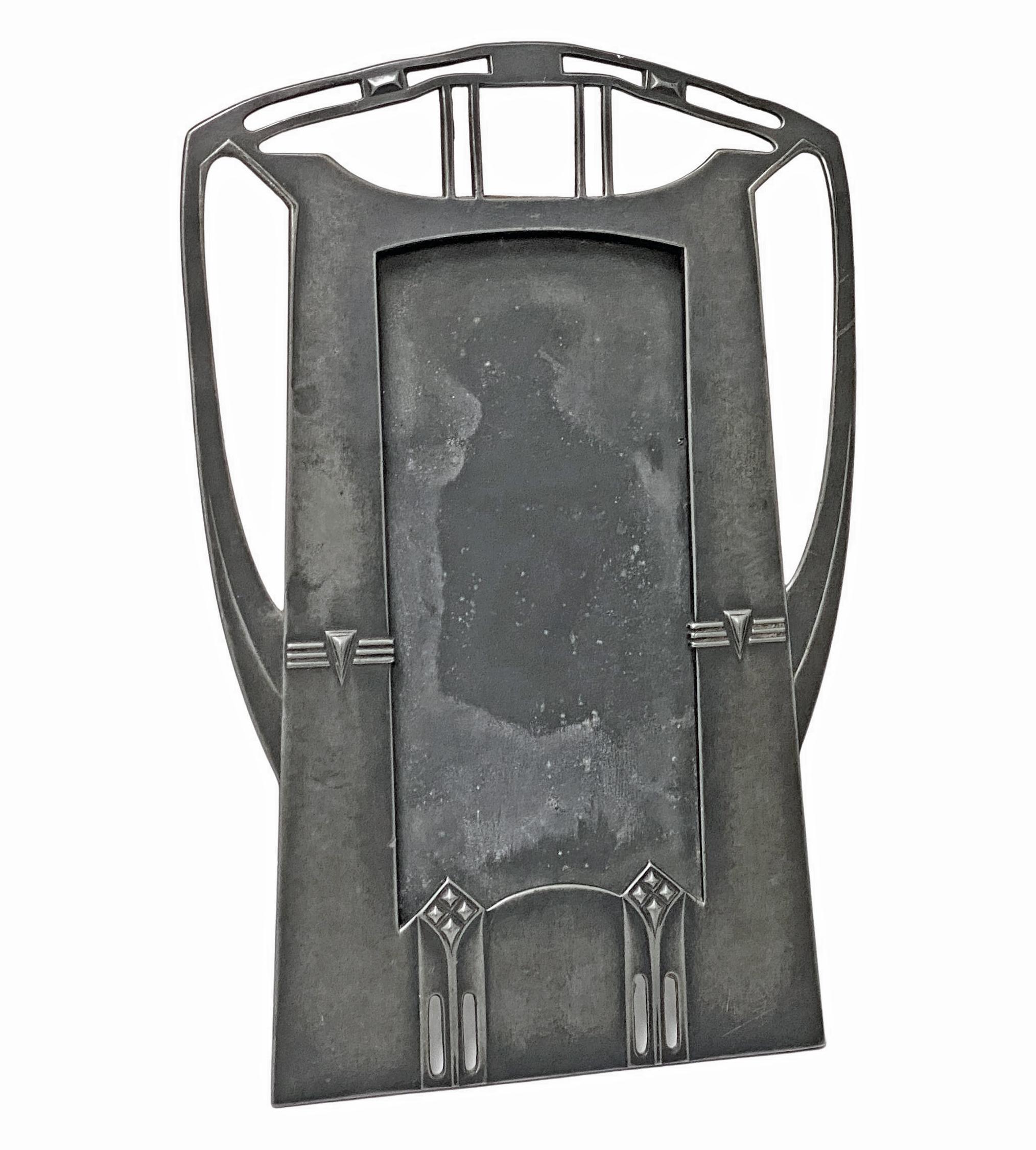 Large Art Nouveau Secessionist pewter photograph frame, WMF, circa 1906.The frame of stylised jugendstil form, the bottom section of pierced gothic like panels, the upper section with cut pierced geometric style design, original easel and leather