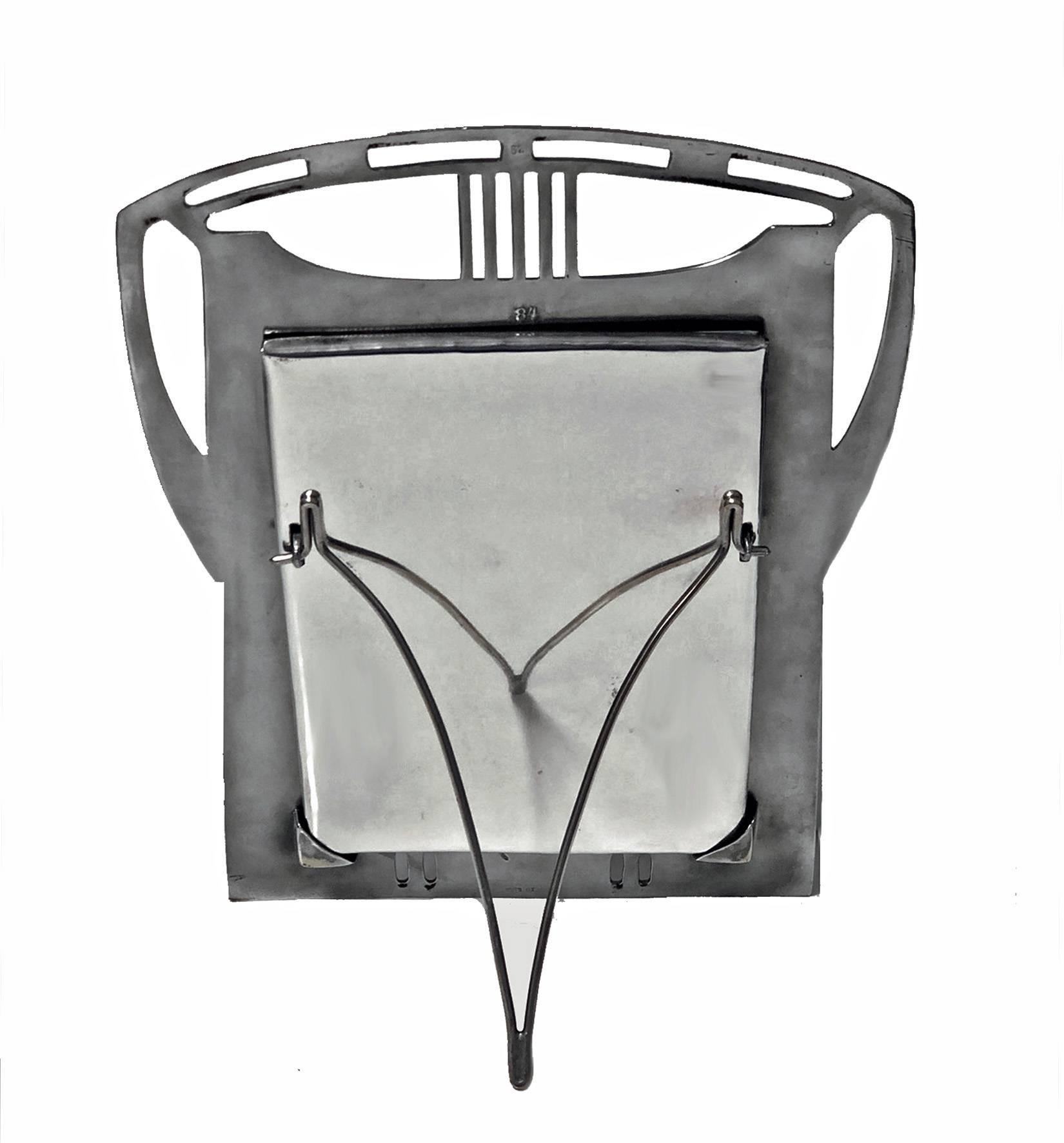 Art Nouveau Secessionist polished pewter photograph frame, WMF, circa 1906. The frame of stylised Jugendstil form, the bottom section of pierced Gothic like panels, the upper section with cut pierced geometric style design, silver plated easel and