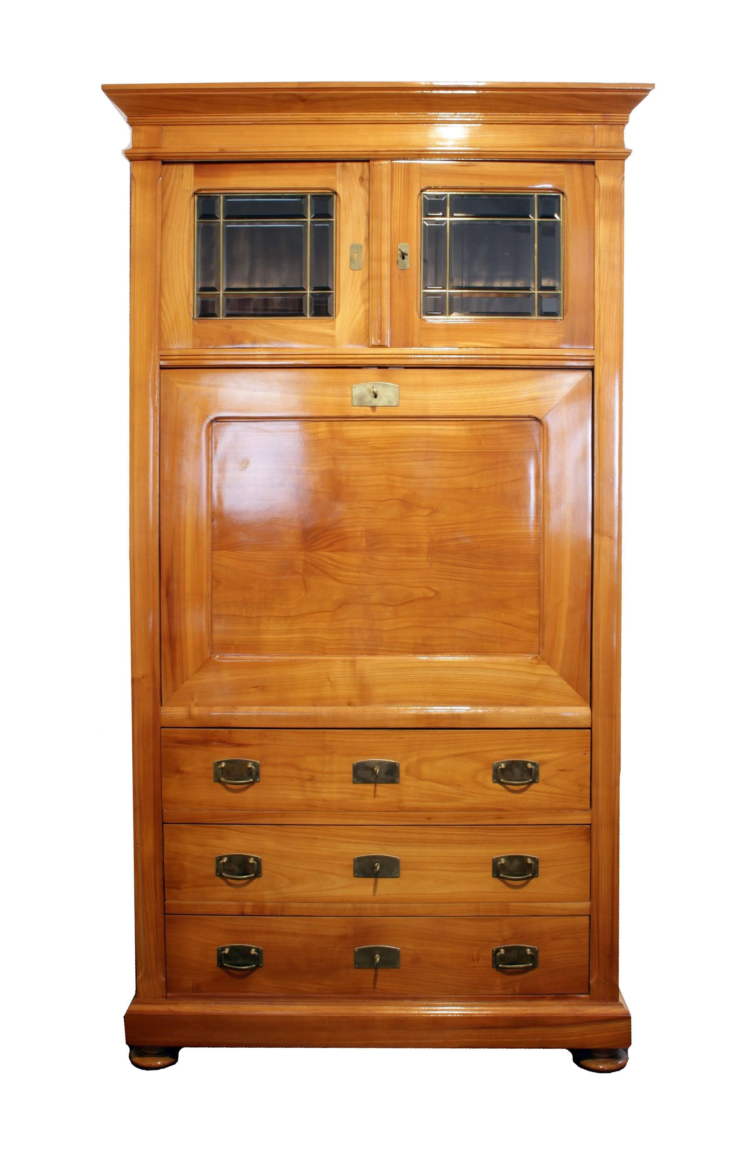 A beautiful Secretaire made of solid cherrywood, from the time of Art Nouveau, circa 1900.
The interior of the middle section was covered with bird’s-eye maple veneer and looks so beautiful. The upper part can be opened via two glass doors. The