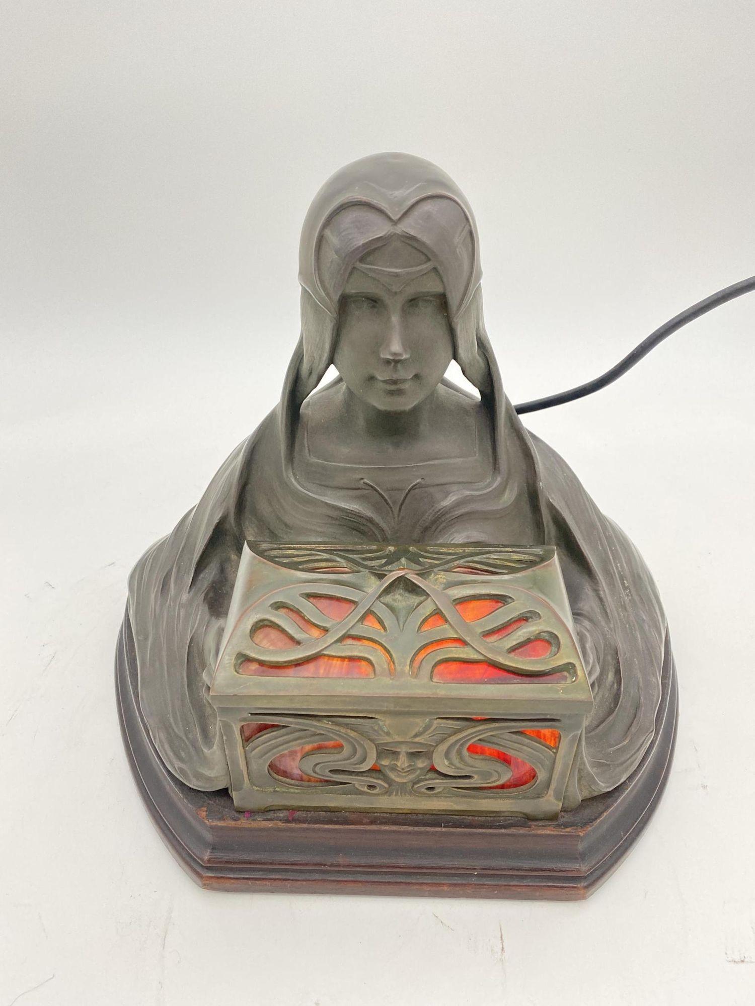 Art Nouveau sculpture by in gilded bronze representing a young girl holding an illuminating casket with panes of marbled red glass resting on a mahogany base.

Great example of Art Nouveau sculpting and casting at its finest , time has given the