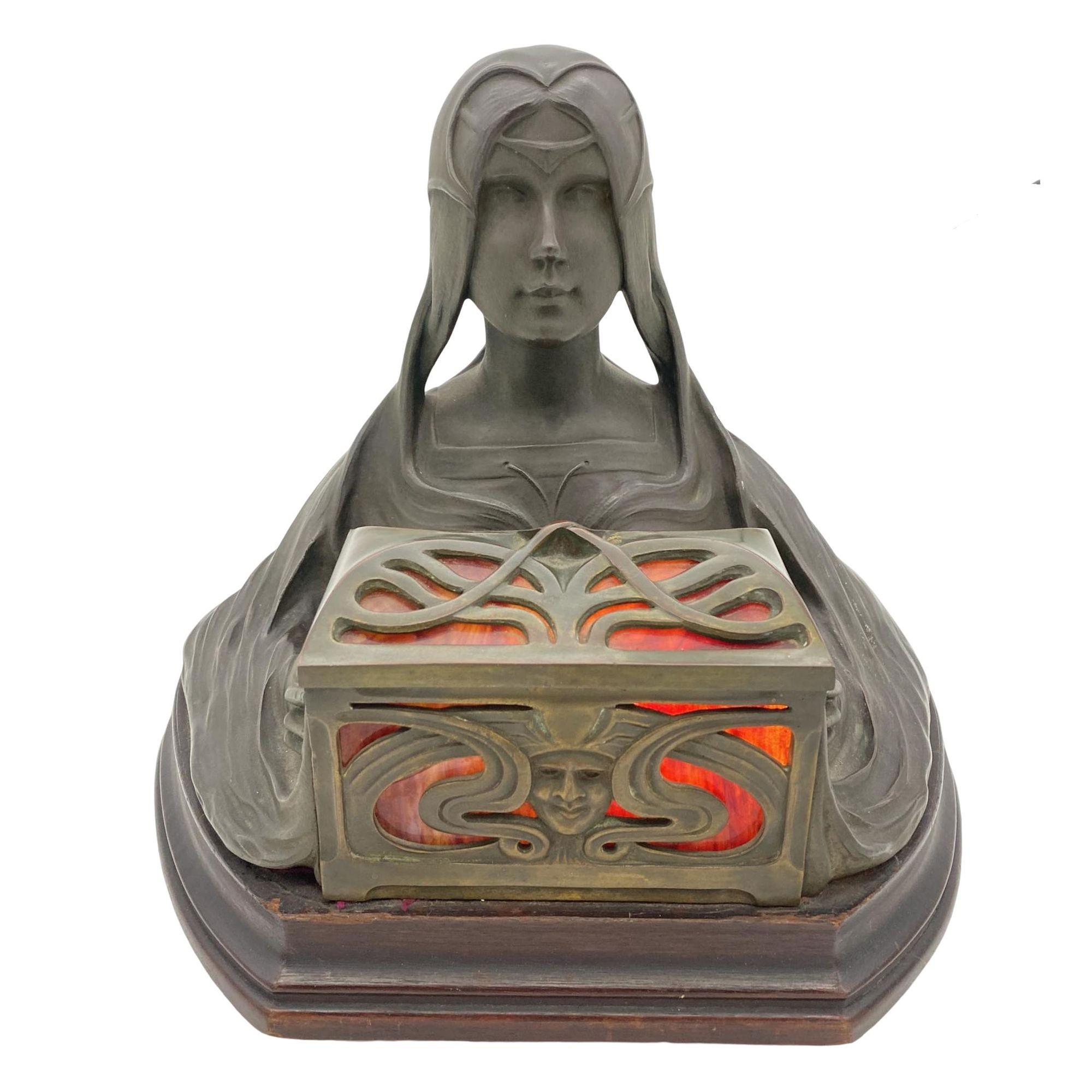 Art Nouveau sculpture by in gilded bronze representing a young girl holding an illuminating casket with panes of marbled red glass resting on a mahogany base.

Great example of Art Nouveau sculpting and casting at its finest , time has given the
