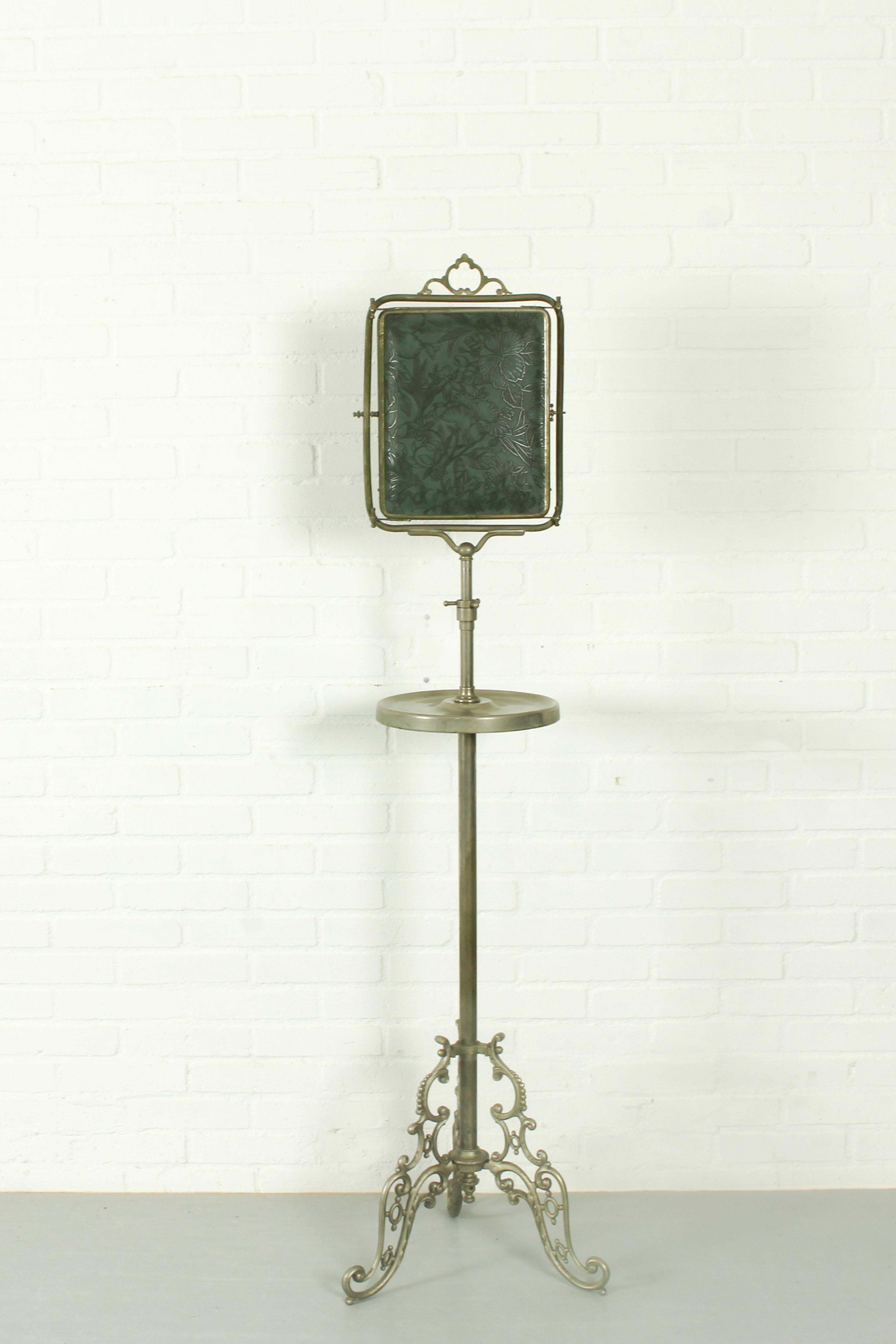 Fantastic and rare shaving mirror on a metal stand. The mirror has three panels, the central one can be adjusted and tilted. See images for embossed leather decorations. 

Dimensions: 150/120cm h, 42cm w.
