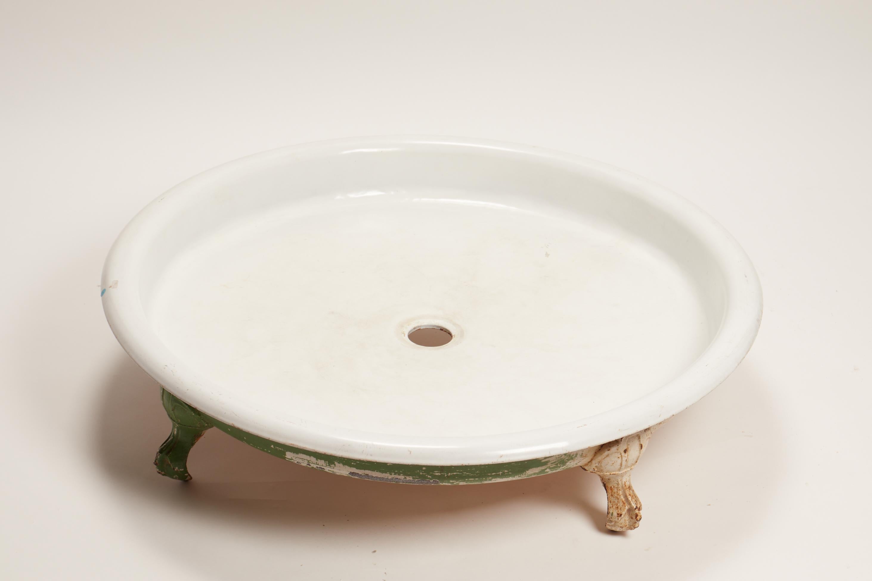 Unusual Art Nouveau round-shaped shower tray in white enameled cast iron with four claw-shaped feet. Cast iron, green painting in the front, France, circa 1900.