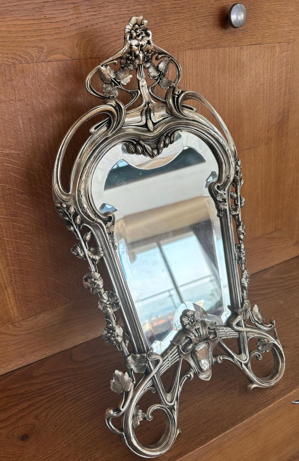 Nineteen century table mirror in silver bronze. This portable mirror is a wonderful representation of the art nouveau movement from the end of the nineteen century to the beginning of the twentieth century. It has the aesthetic of the curves lignes