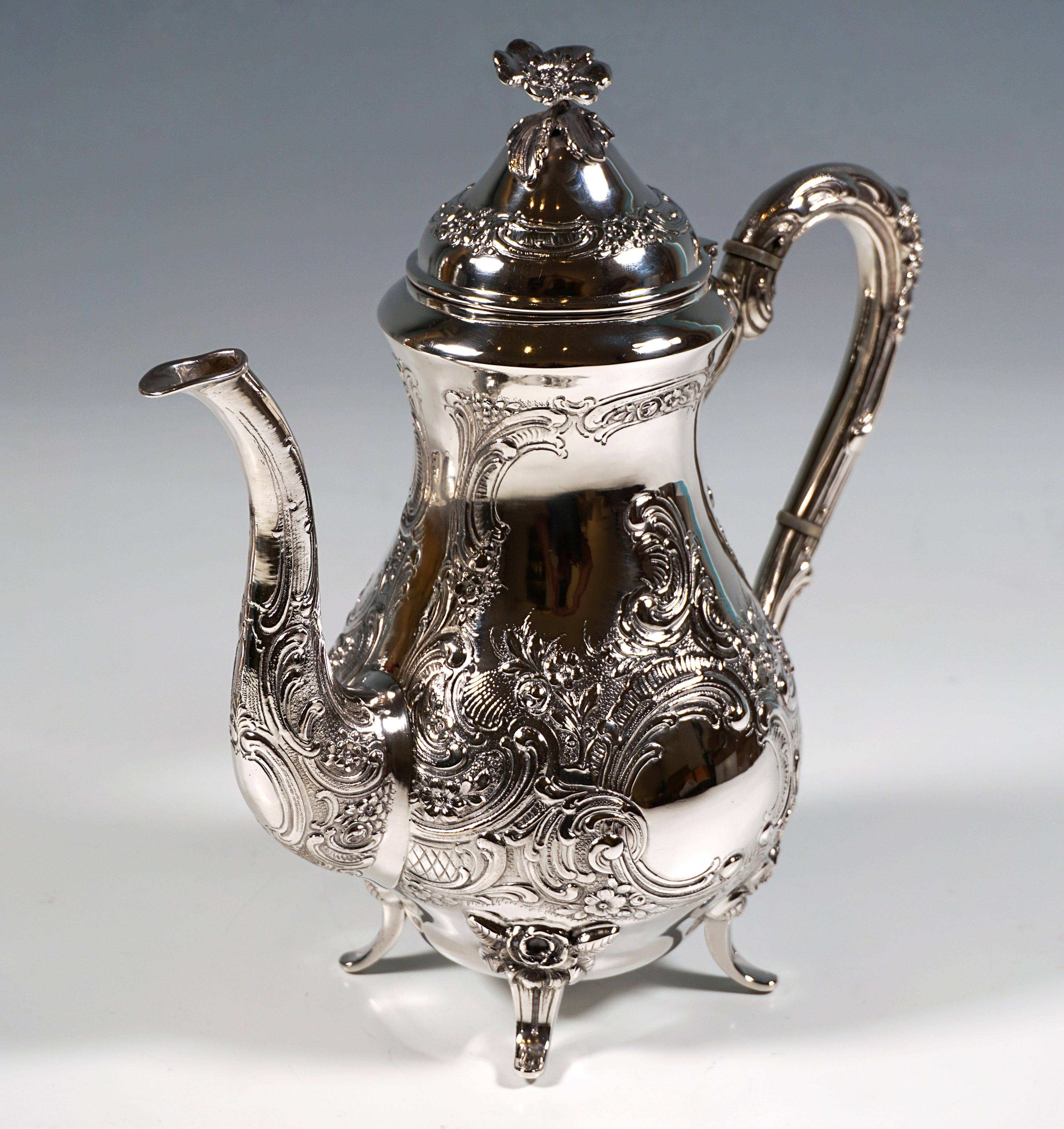Festiva cafetera o tetera de plata: forma de pera, cuerpo bulboso elevado, estrechándose de nuevo hacia la abertura, de pie sobre cuatro pies aplicados, pared decorada con rica decoración en relieve y cincelado de rocaille y voluta con elementos