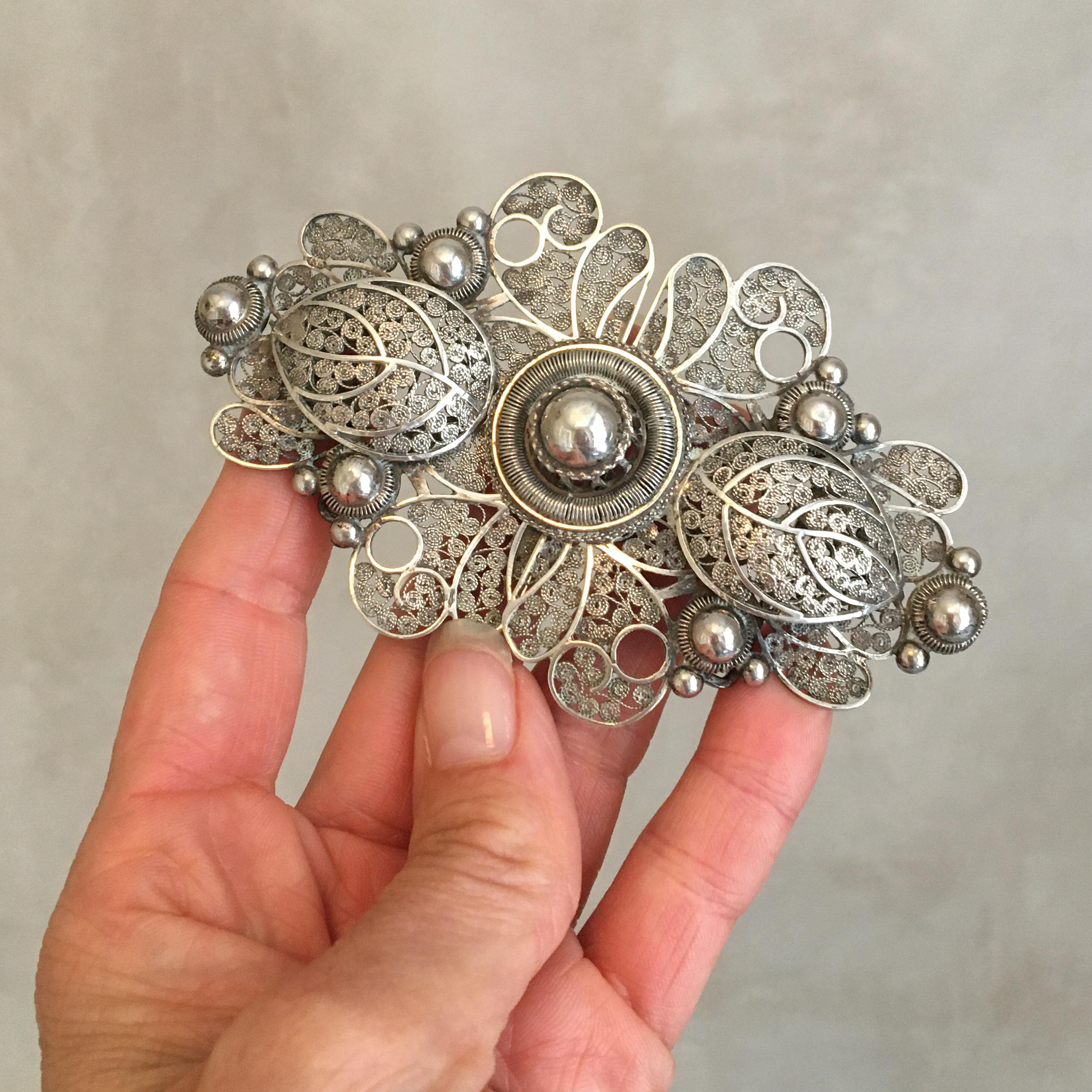 This Art Nouveau belt buckle is made out of silver which shows a beautiful opulent presentation. The buckle has a scrolling foliage openwork design, depicting leaves and spheres. The buckle is stamped with the Dutch old sword hallmark (1910-1921)