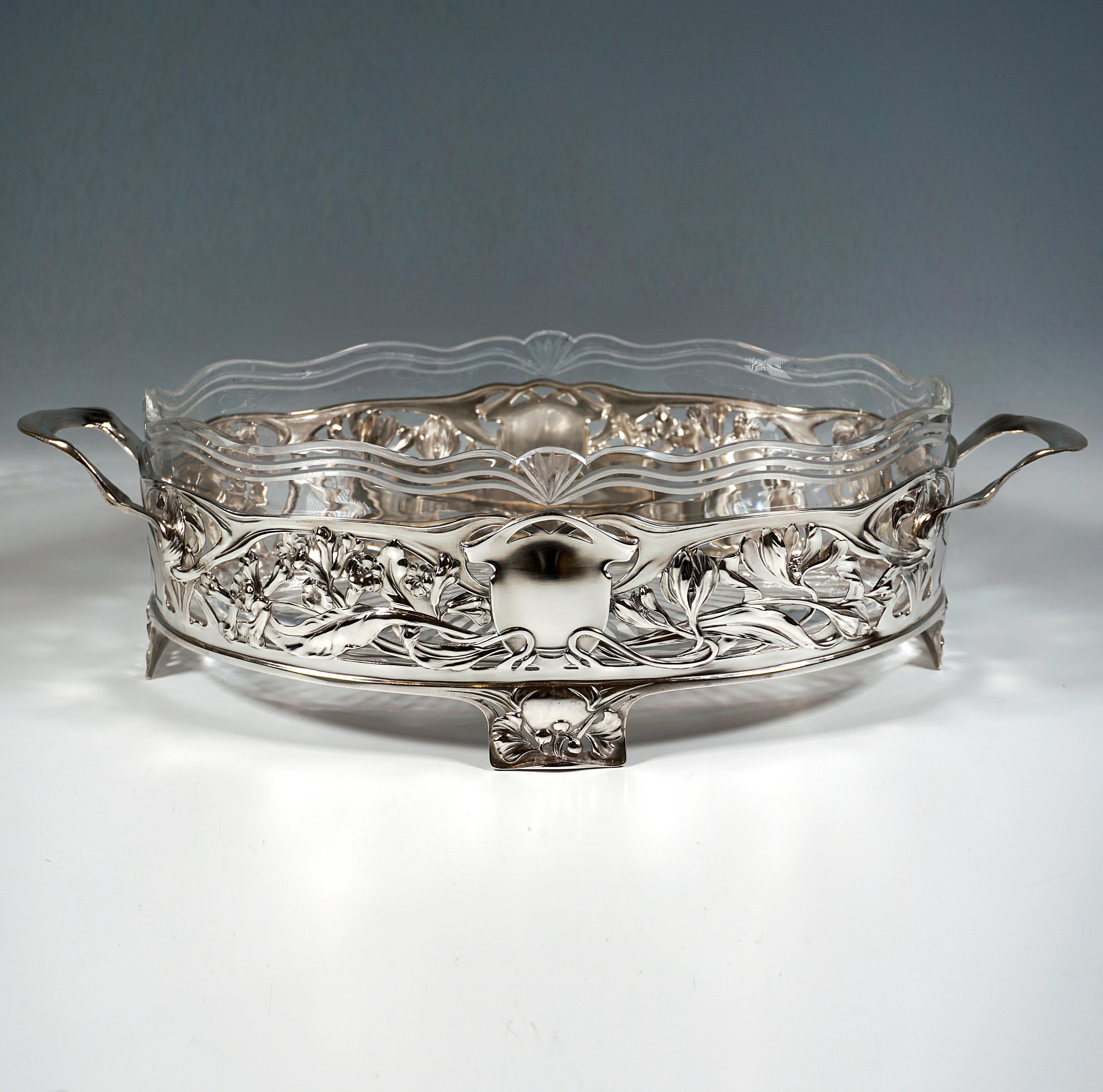 Elegant, festive silver vessel with a wide oval vertical wall standing on four feet attached to the lower rim, central cartouches on the front and back, supported by a surrounding, relief and openwork flower and leaf interlacing, slightly curved