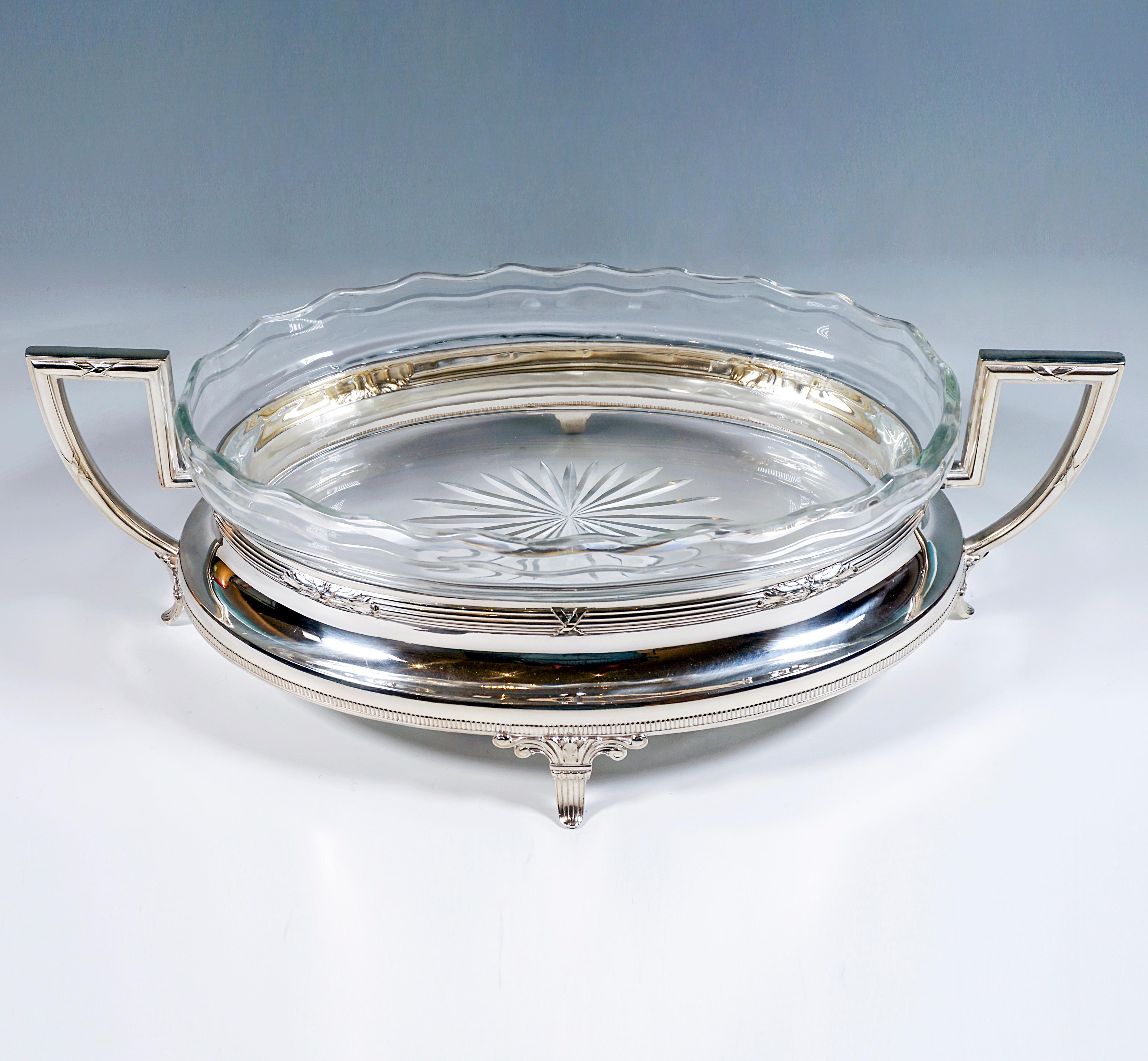 Elegant silver jardinière of elliptical base form on four flared feet with volute bond, downwardly flaring smooth wall with delicate ribbed band at the lower rim, constriction at the upper rim by profiled cross band with floral ornamental elements,