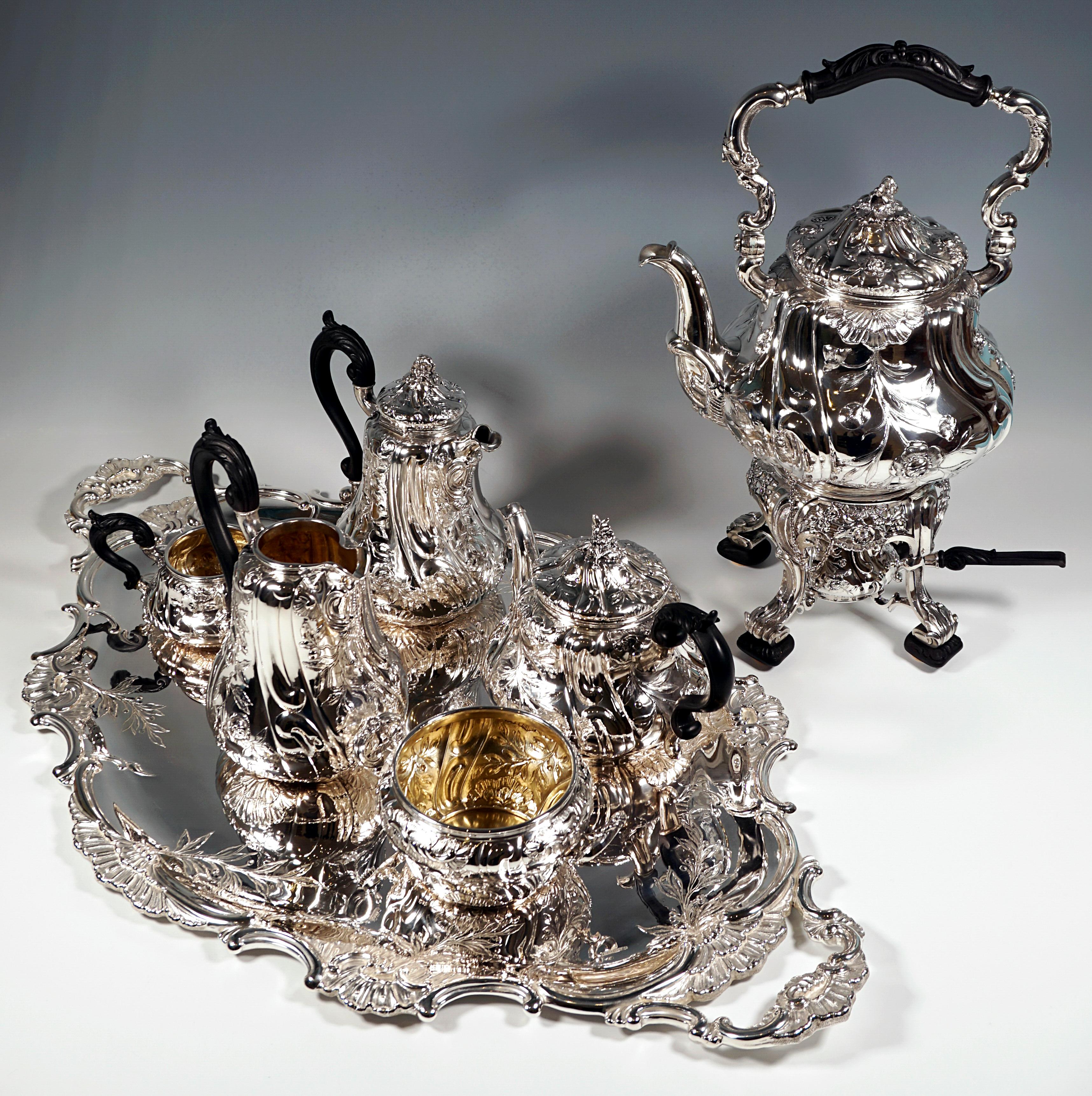 Excellent, complete silver coffee and tea set consisting of 8 pieces, pear-shaped pots, walls richly decorated with floral Art Nouveau motifs - leafy tendrils with berries and flowers, as well as volutes and rocailles covering the entire surface,