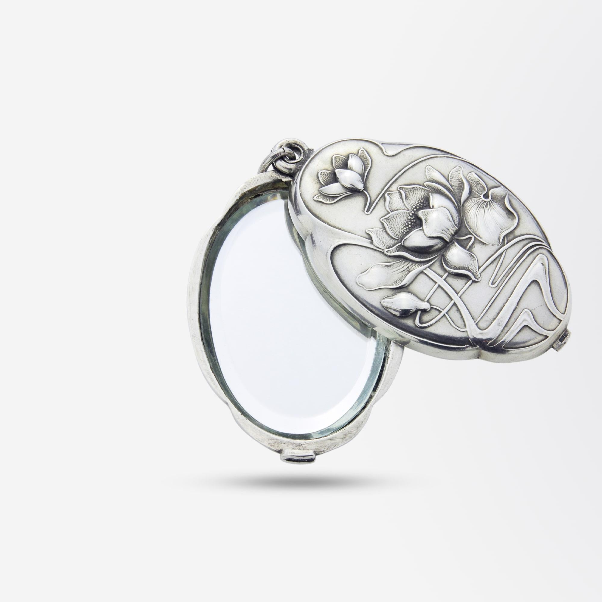 An Art Nouveau silver pendant decorated with water lilies, likely French. The pendant slides open to reveal a pair of oval mirrors to the interior. The mirrored interior is likely a later addition, with the piece most probably originally a locket