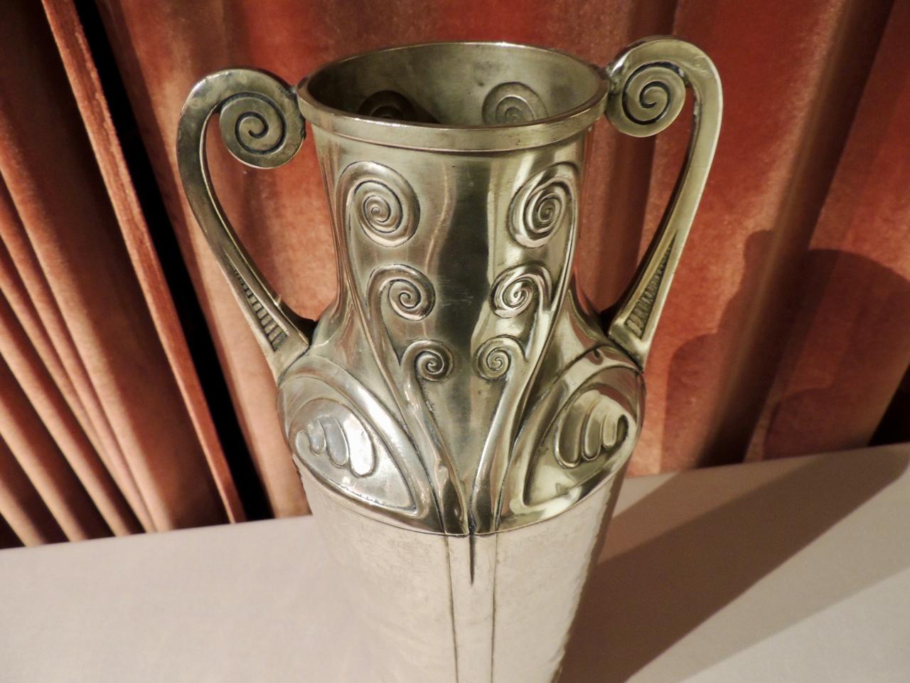 Diese hohe Silbervase im Jugendstil mit handgehämmerten Details wurde Anfang 1900 in Deutschland hergestellt. Entworfen von Carl Deffner aus Esslingen, der 1856 geboren wurde und im Jahr 1900 die Leitung der väterlichen Metallwarenfabrik übernahm.