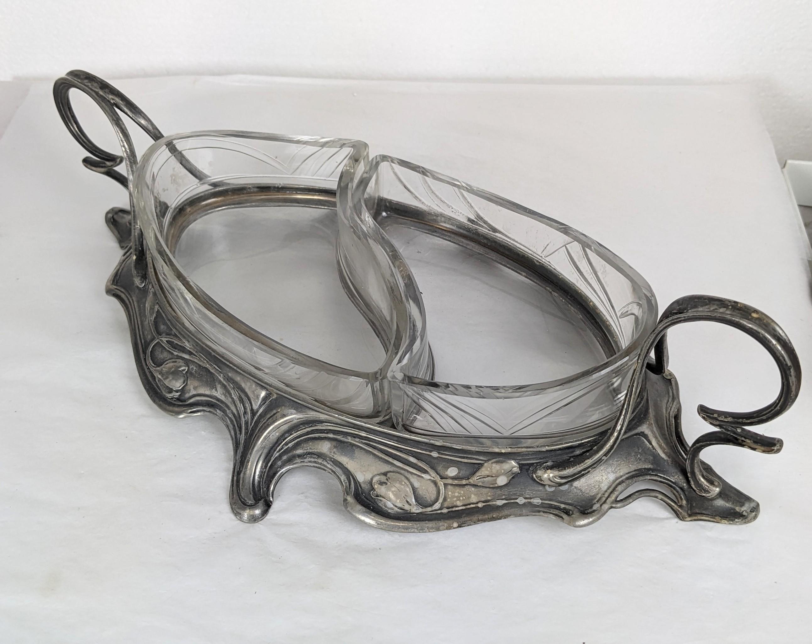 Elegantes Serviergeschirr aus versilbertem Jugendstil europäischer Herkunft um 1900. 2 gravierte Glasscheiben lassen sich zum Reinigen herausnehmen und folgen den wellenförmigen Linien des Rahmens. Griffe im Peitschendesign mit