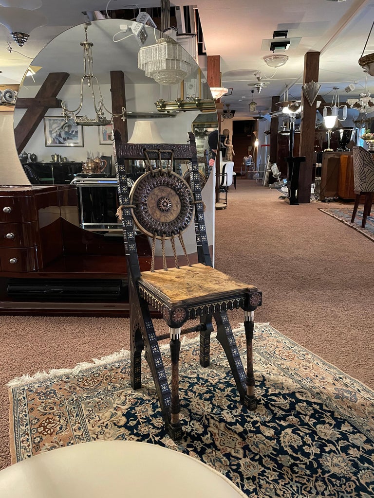 Small chair from Carlo Bugatti. 
Suitable for a hairdresser, or as a decorative eye-catcher. 

Various materials:
among others walnut, parchment, leather, brass, copper, pewter

Rich ornamentation. 
Carlo Bugatti's furniture is strongly