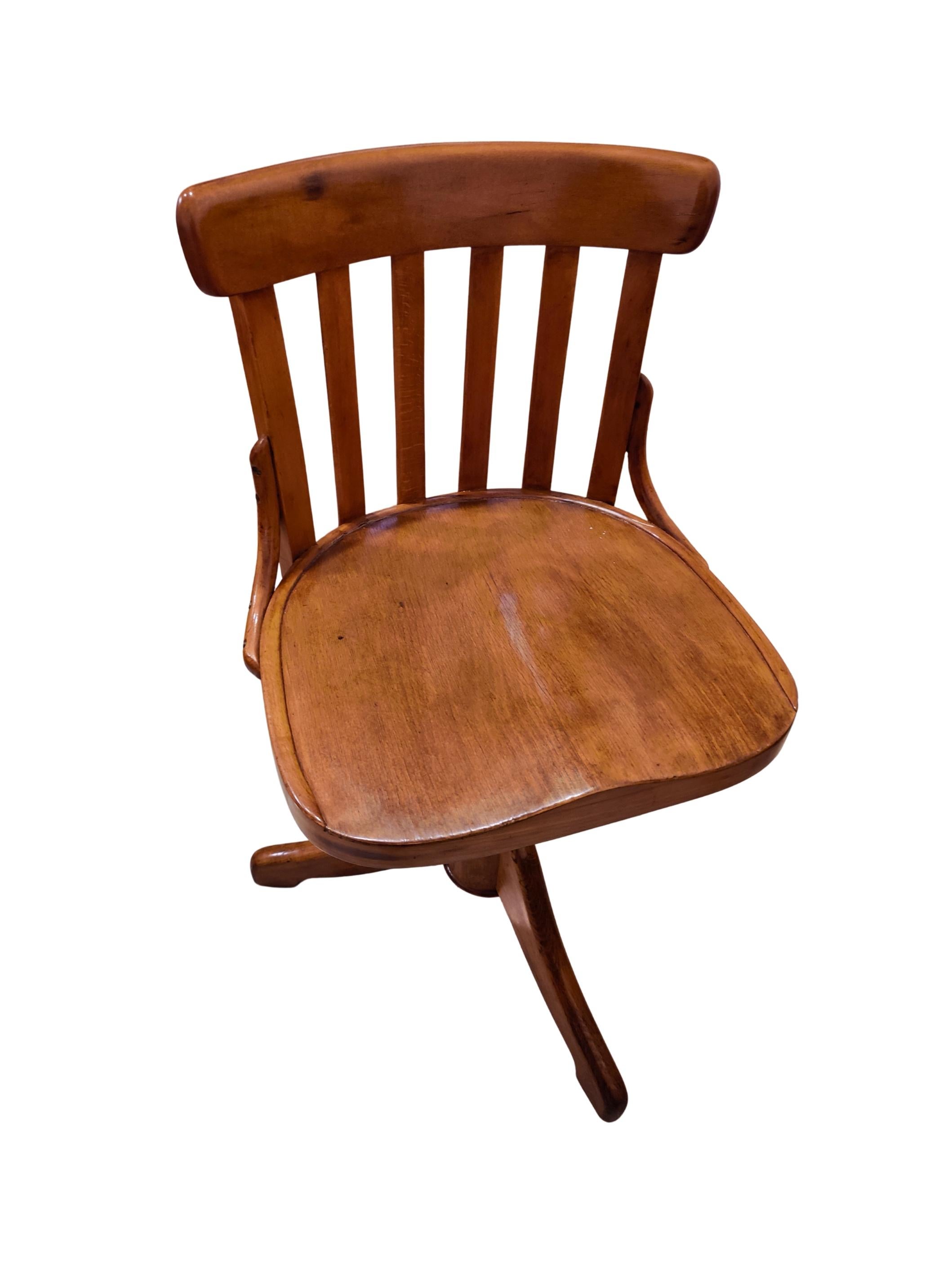 This Art Nouveau swivel chair from around 1900 is made of solid beechwood and impresses with its sculptural form and functional elegance. The seat height can be individually adjusted by turning the central screw mechanism – the chair can be raised