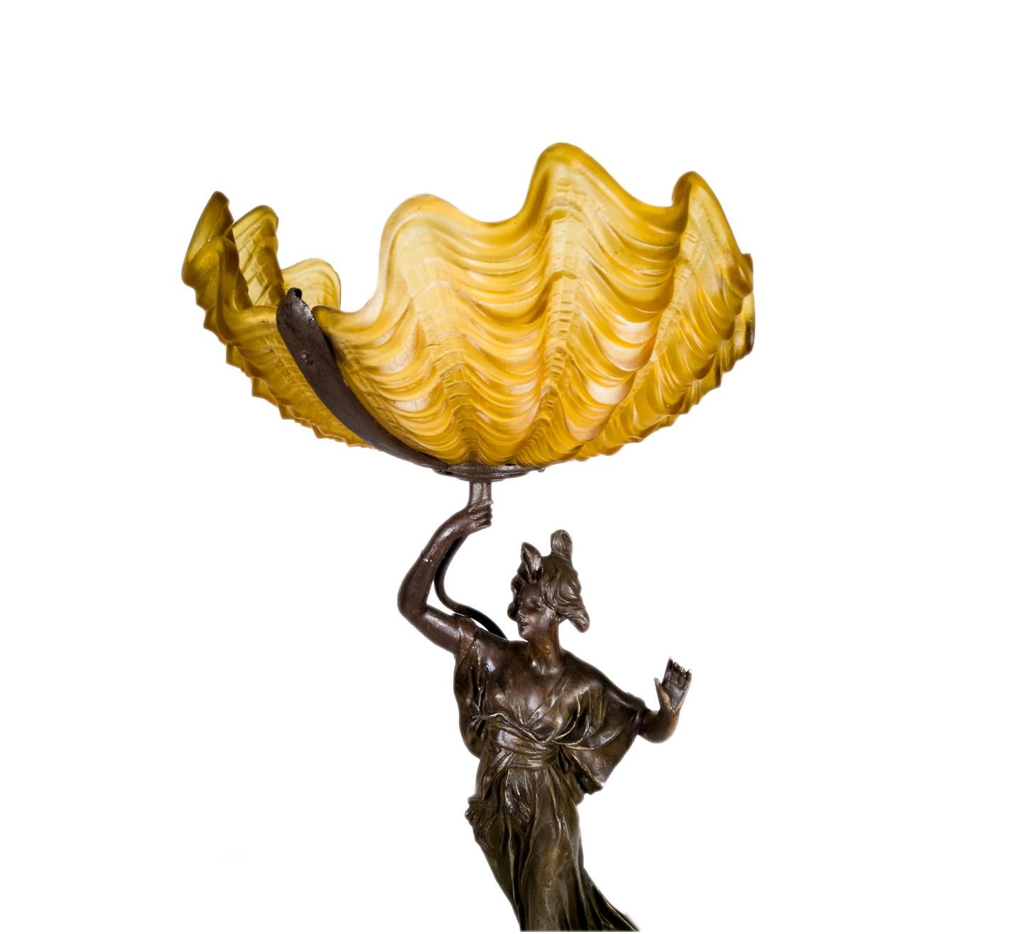 A 19th century Belle Époque Art nouveau french spelter sculpture statue lam of a woman holding a illuminated  yellow tulip shaped glass.