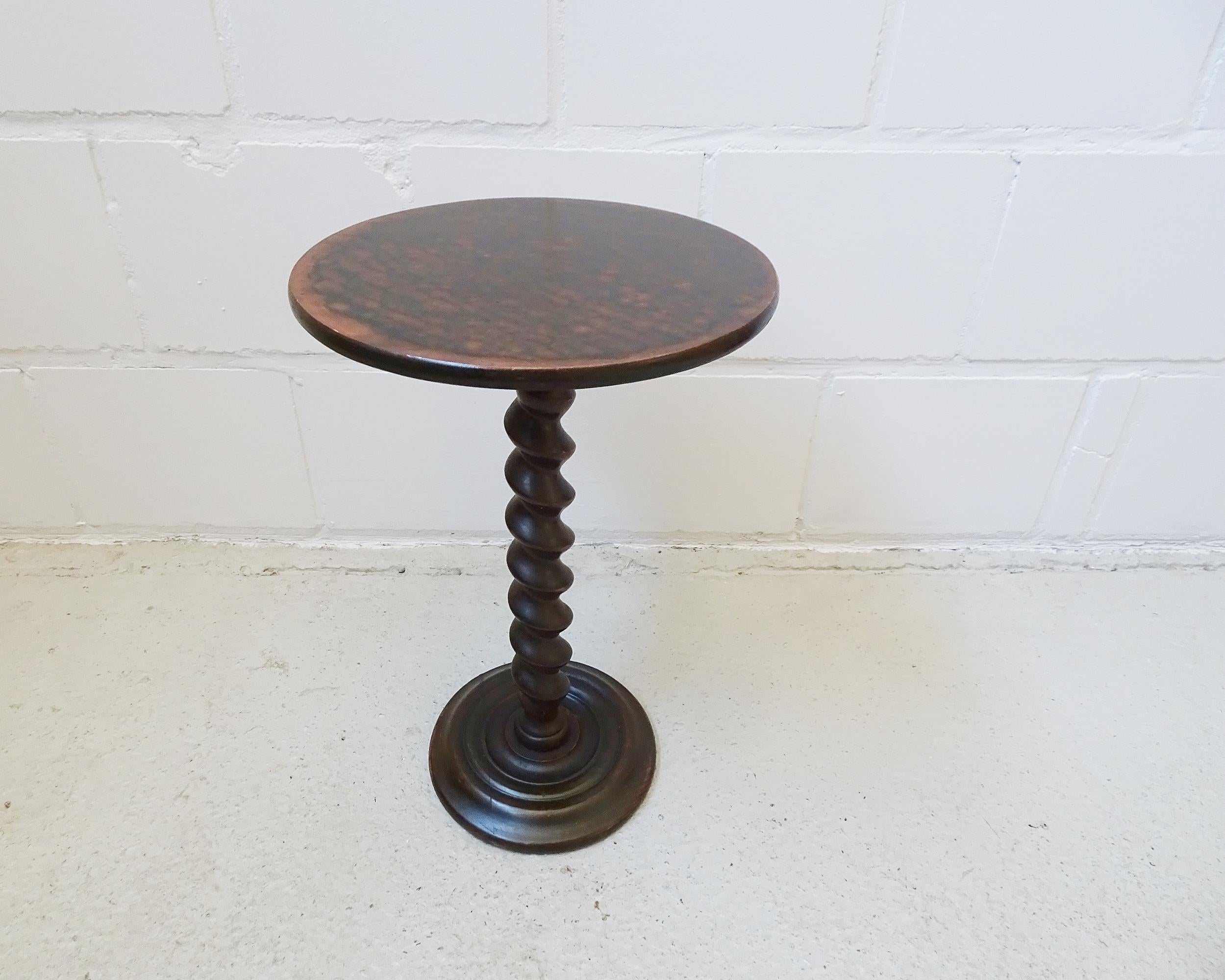This round table is a practical wooden side table that can be used in many ways. A great accent is the turned spiral leg and the original dark wood stain. Delicate and simple, a medium-sized column, plant stand or side table.