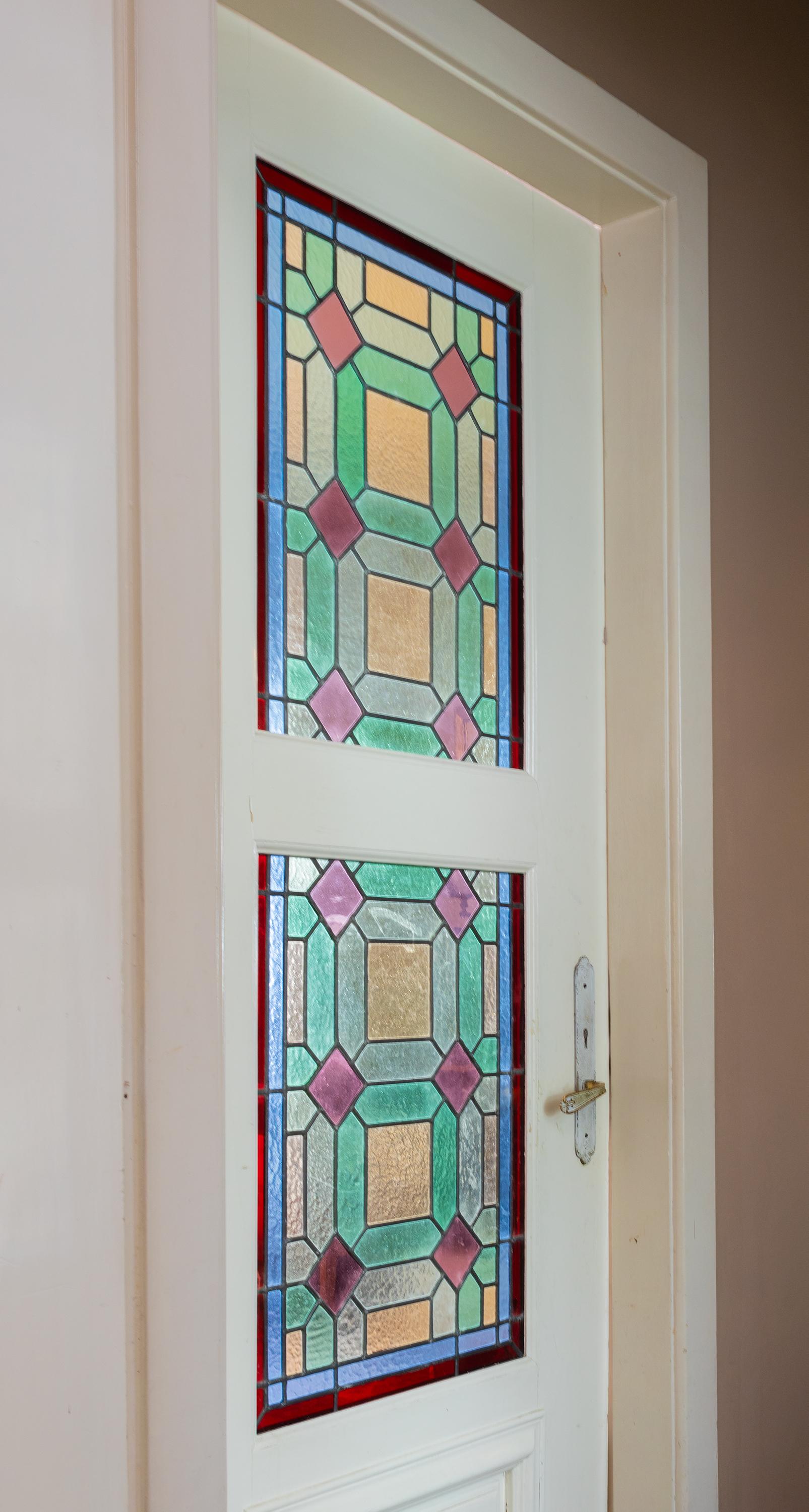 Set of 10 stained glass windows in five doors with brass handles. 
Beautiful stained glass from the Art Nouveau period with rich polychrome decoration. Each door has two glass panels framed in original lead channels

Doors: 30,9 x 82,28 in (78,5 x
