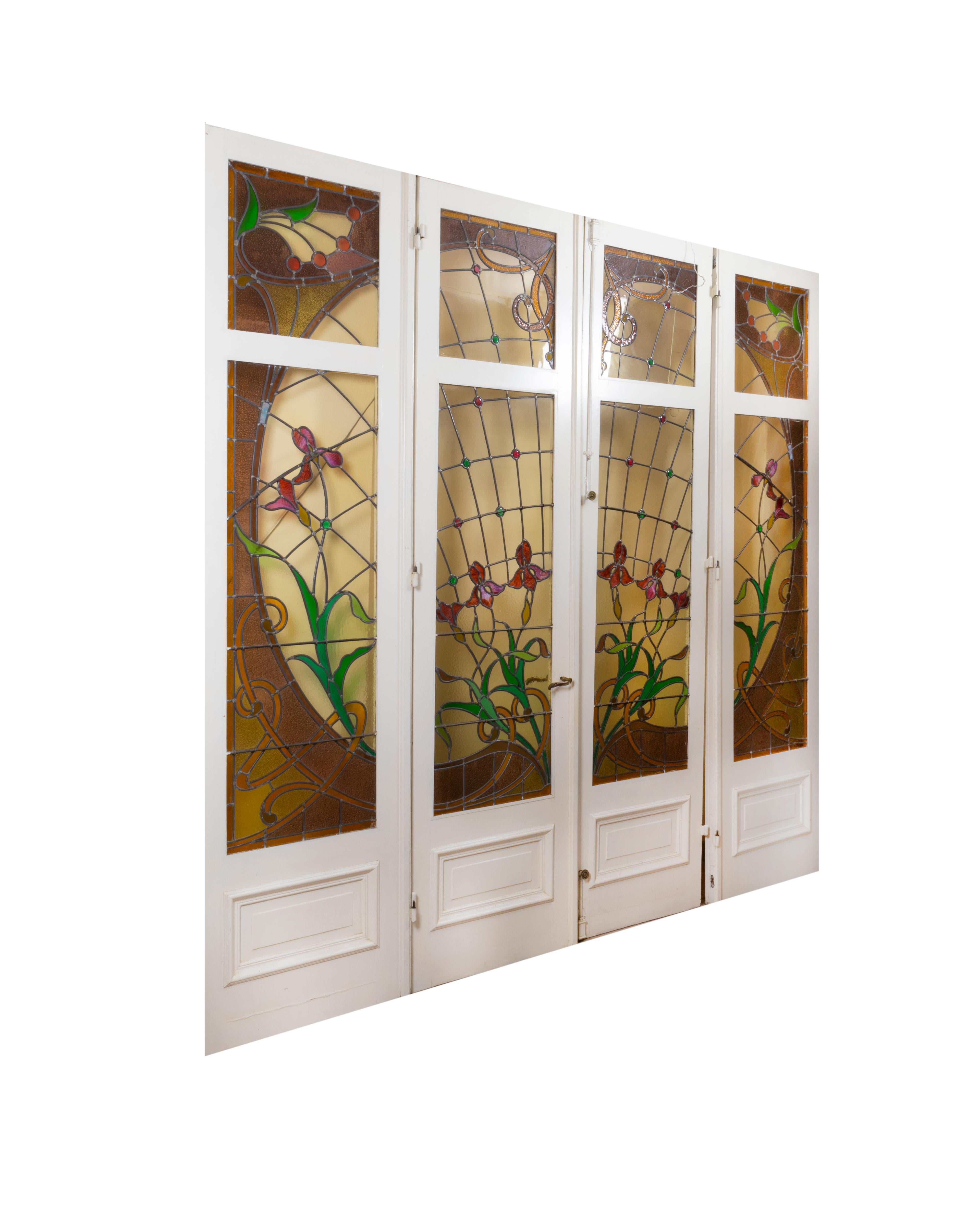 A wonderful set of eight French stained glass windows in four doors with bronze handles. The set of eight panels is in stained glass in polychrome glass with shutters, locks, handle and original key.  

Beautiful stained glass from the Art Nouveau